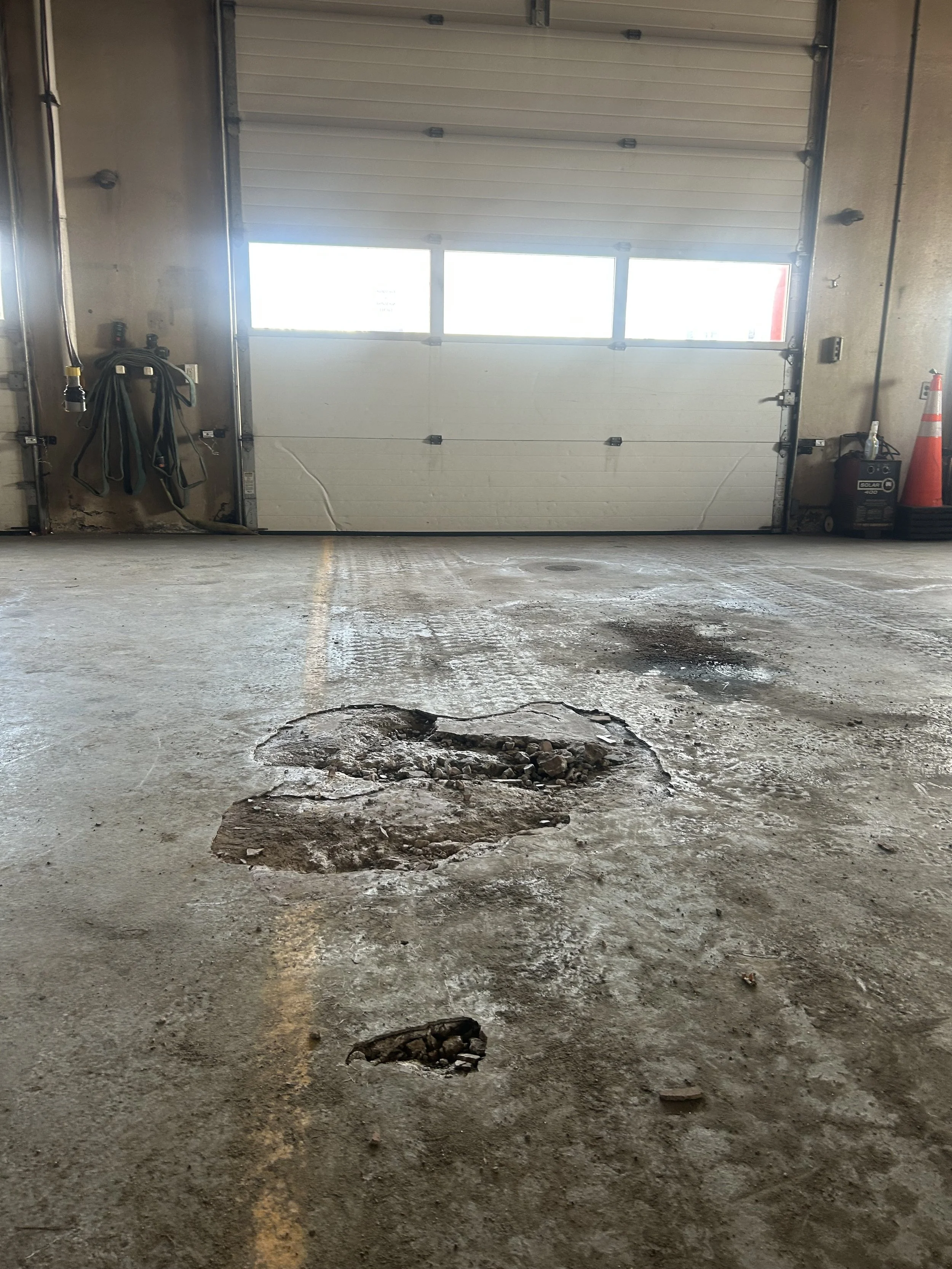 Damage in the apparatus bay floor near garage doors