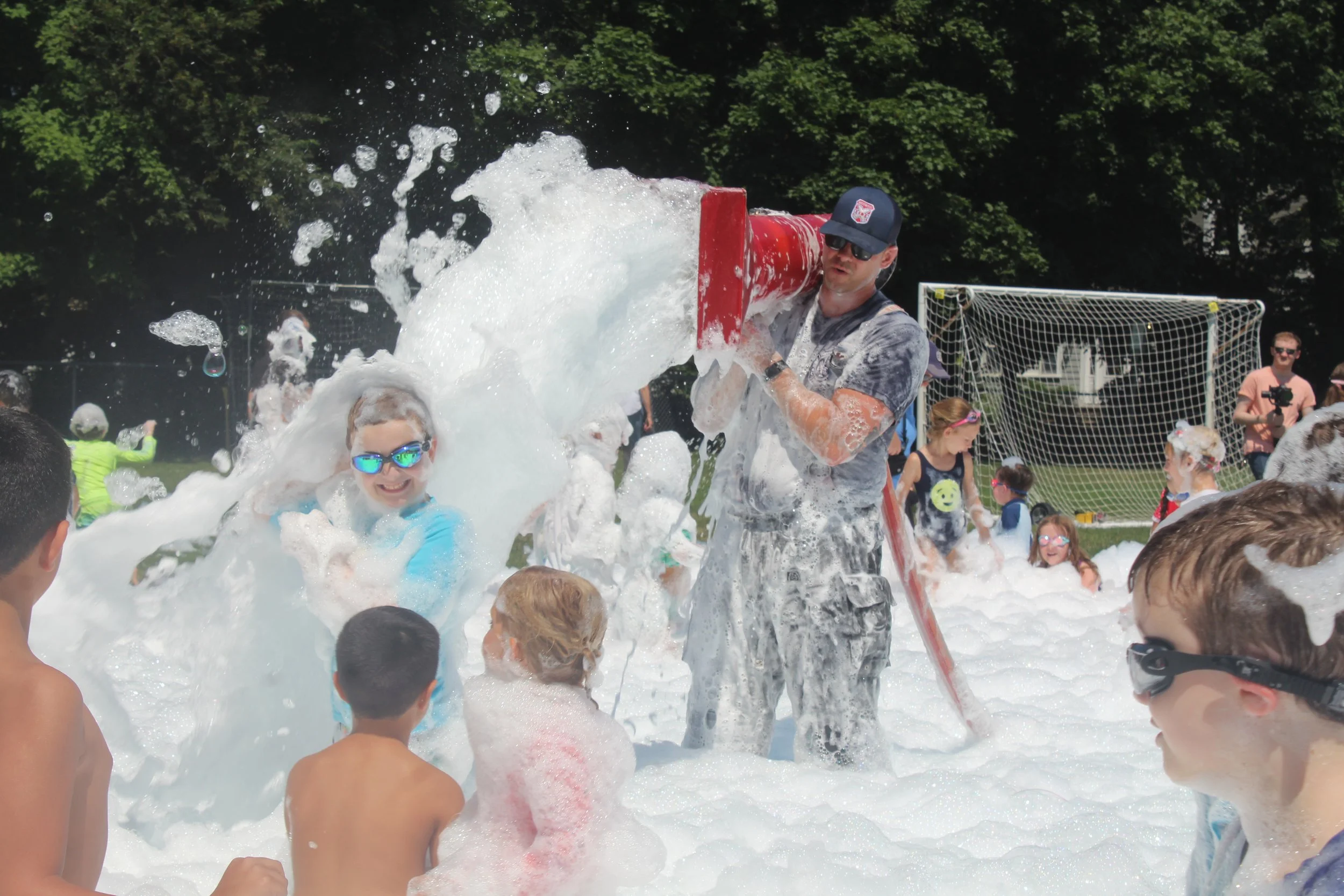 A Westwood firefighter is surrounded by children as he participates in the 2026 Firefighters Foam