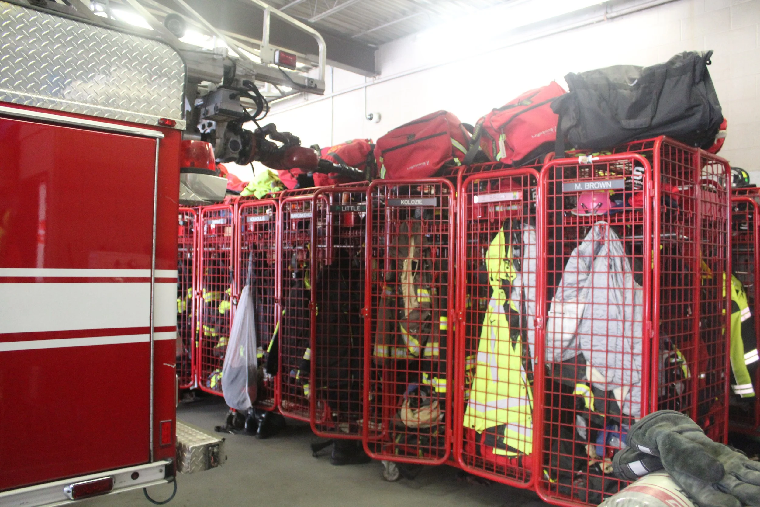 Image of turnout gear being stored behind a fire truck inside the apparatus bay