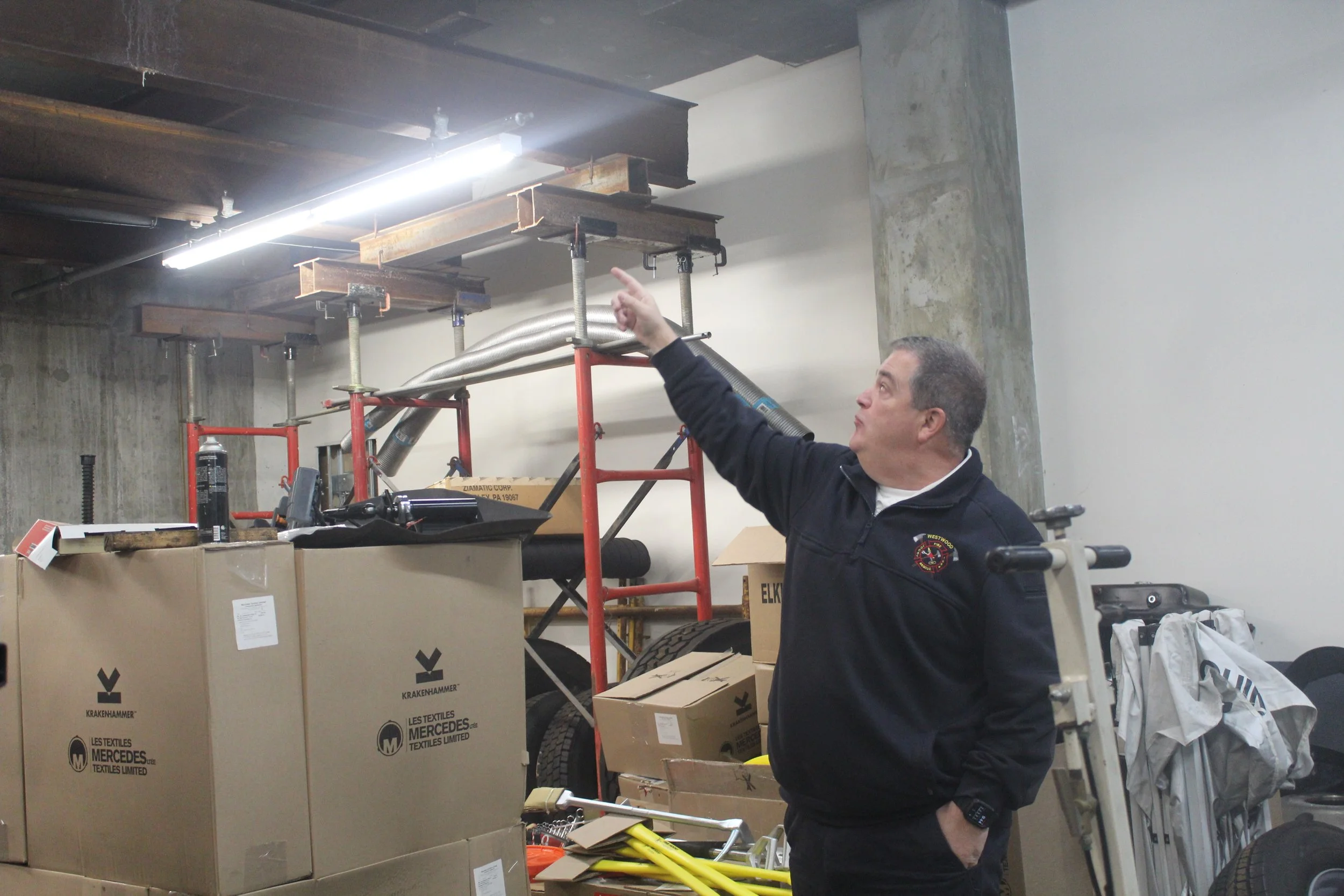 Chief Steve Lund pointing to damage in the ceiling of the mechanic's bay