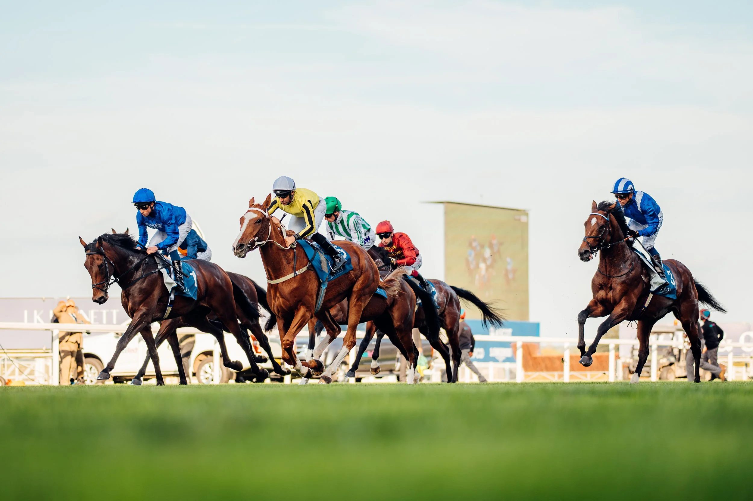 Jockeys driving their horses toward the finish line during a competitive flat race fixture at Ascot Racecourse, Berkshire. High-speed sports action and professional equestrian event photography by Will Bailey.
