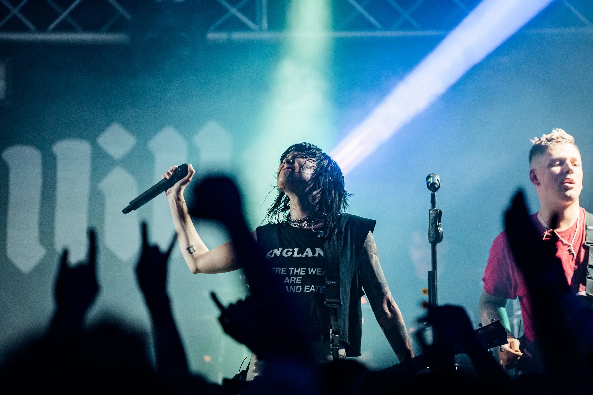 The lead vocalist of Hot Milk performing passionately mid-song while backlit by intense concert beams at an independent music venue in Southampton, Hampshire. Professional live band promotion and touring artist photography by Will Bailey.