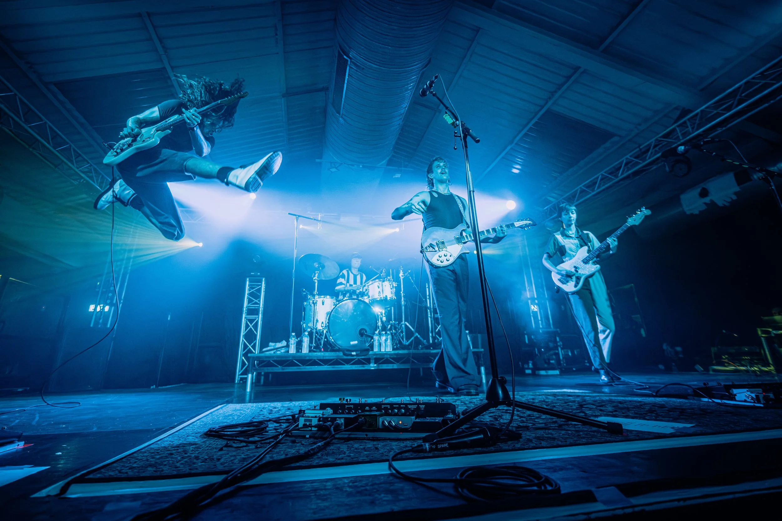 Australian indie rock band Spacey Jane captured mid-air during an energetic, synchronized jump performance at an independent Hampshire live room in Southampton. Professional live music promotion and touring indie band photography by Will Bailey.