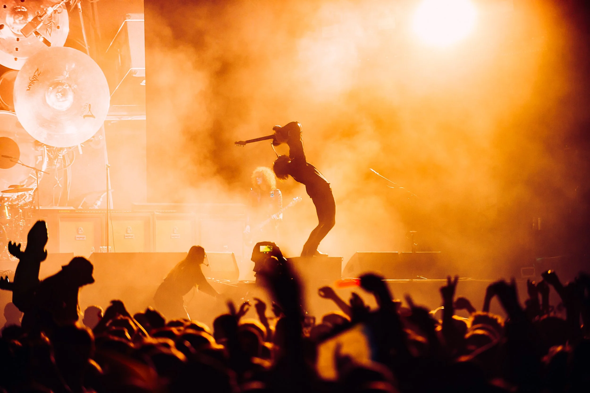 Dynamic rock stage photography of Ryan McCann from Catfish and the Bottlemen arching back with guitar held high amid heavy stage fog at Boardmasters Festival, by Will Bailey.