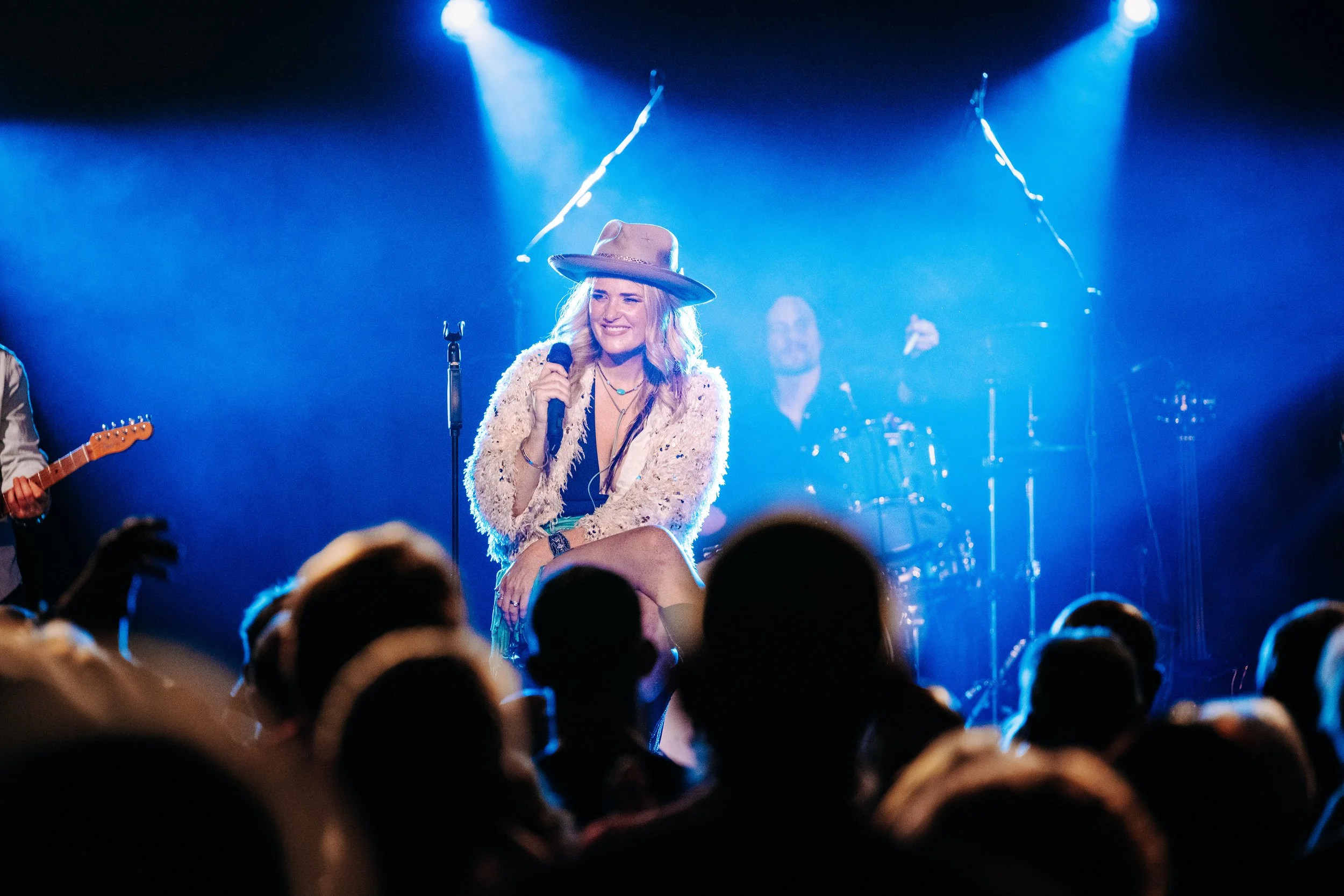 Award-winning blues-rock artist Elles Bailey performing a soulful acoustic set with her guitar under atmospheric stage spotlights at an independent Hampshire live room in Southampton. Professional touring artist marketing and independent UK music sce