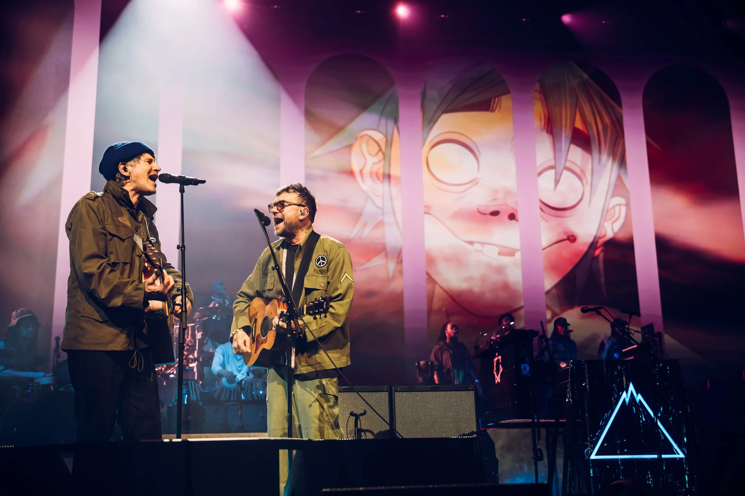 Damon Albarn of Gorillaz performing alongside special guest Gruff Rhys live under a bright spotlight at the Utilita Arena Cardiff, Wales. Elite rock collaborator performance and high-profile stage entertainment photography by Will Bailey.