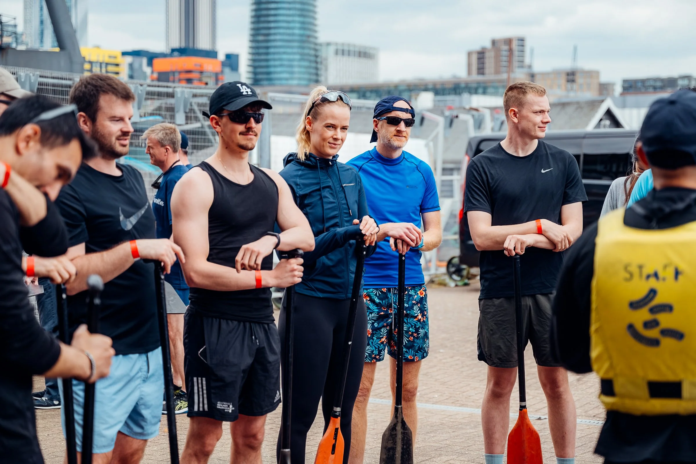 Participants listening to a pre-race team briefing at the Far East Consortium (FEC) Charity Dragon Boat Festival in London. Corporate away day and team building photography by Will Bailey.