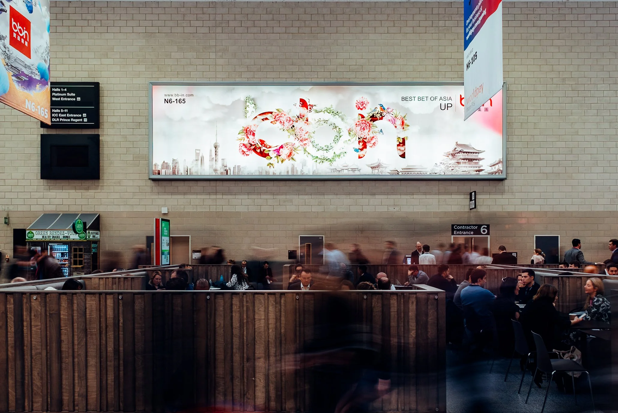 Large-scale commercial brand signage and attendee foot traffic for BBIN at the ICE London expo, ExCeL London. Premium corporate exhibition and sponsorship photography by Will Bailey.