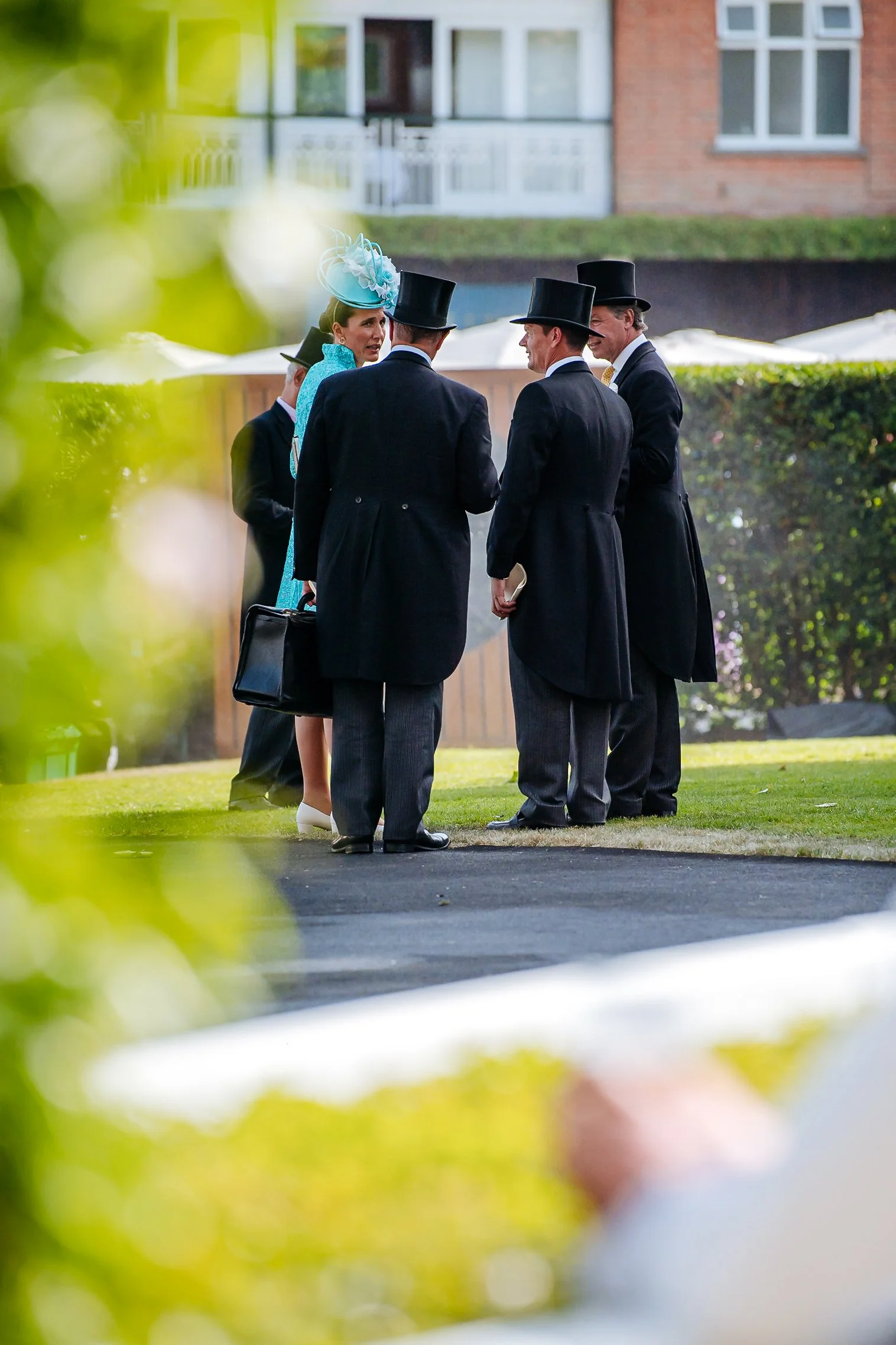 Guests in formal morning dress and top hats gathering in the exclusive Royal Enclosure at Royal Ascot. Luxury corporate hospitality and high-society lifestyle photography by Will Bailey.