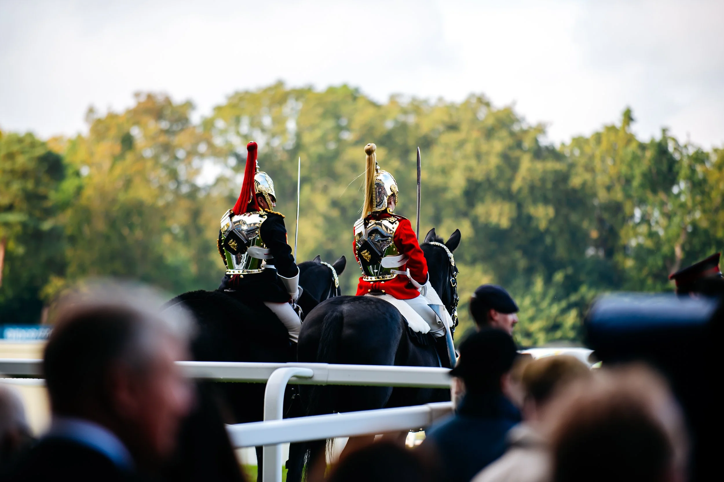 Mounted members of the Household Cavalry in ceremonial uniform on the track during the prestigious British Champions Day at Ascot, Berkshire. Traditional state pageantry and elite autumn sporting season photography by Will Bailey.