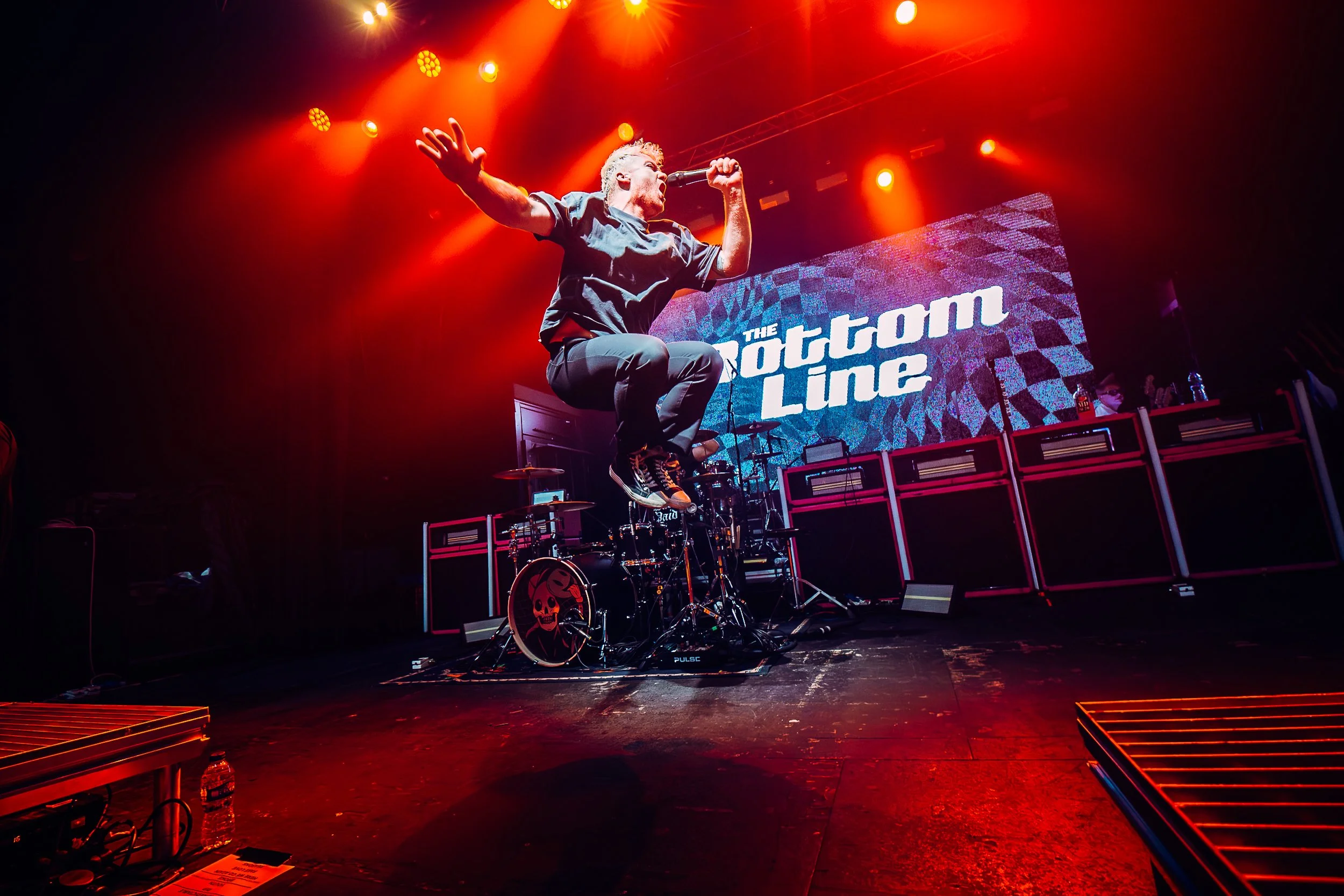 Cal Amies, lead vocalist of pop-punk group The Bottom Line executing an explosive mid-air jump over the stage at the NX Newcastle venue. Professional national music tour documentary photography by official tour photographer Will Bailey.