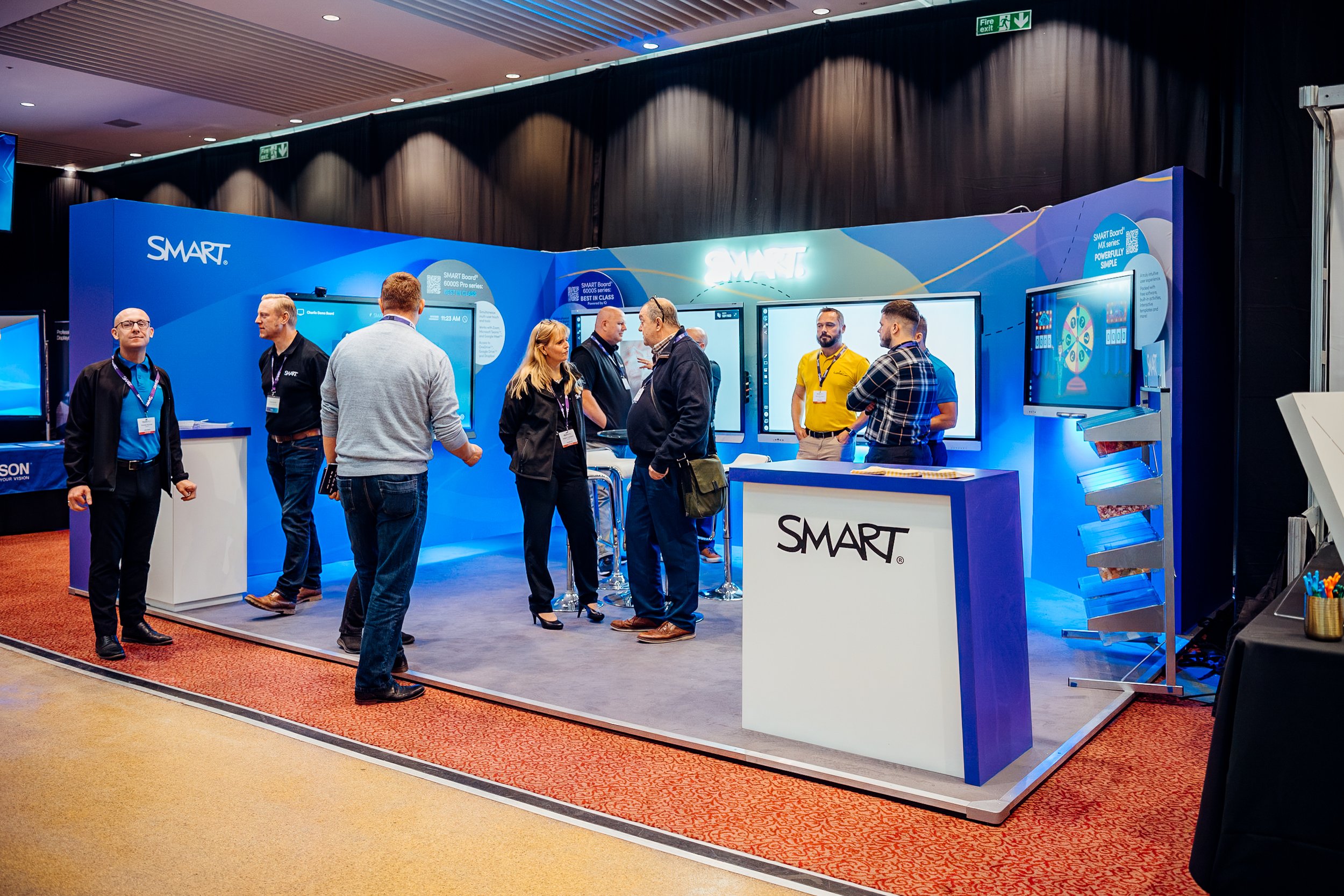 Delegates exploring the interactive custom booth for SMART Technologies during the Midwich Tech Xpo at Ascot. Commercial trade show and exhibition photography by Will Bailey.