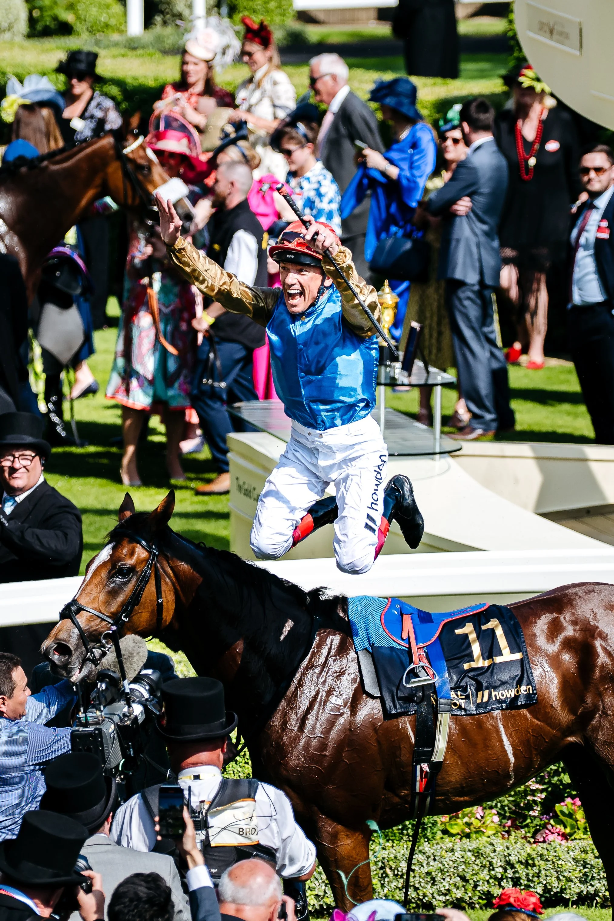 Legendary jockey Frankie Dettori executing his iconic "flying dismount" celebration in the winner's enclosure after winning the Gold Cup at Royal Ascot, Berkshire. Historic sports photojournalism and prestigious racing milestone photography by Will B
