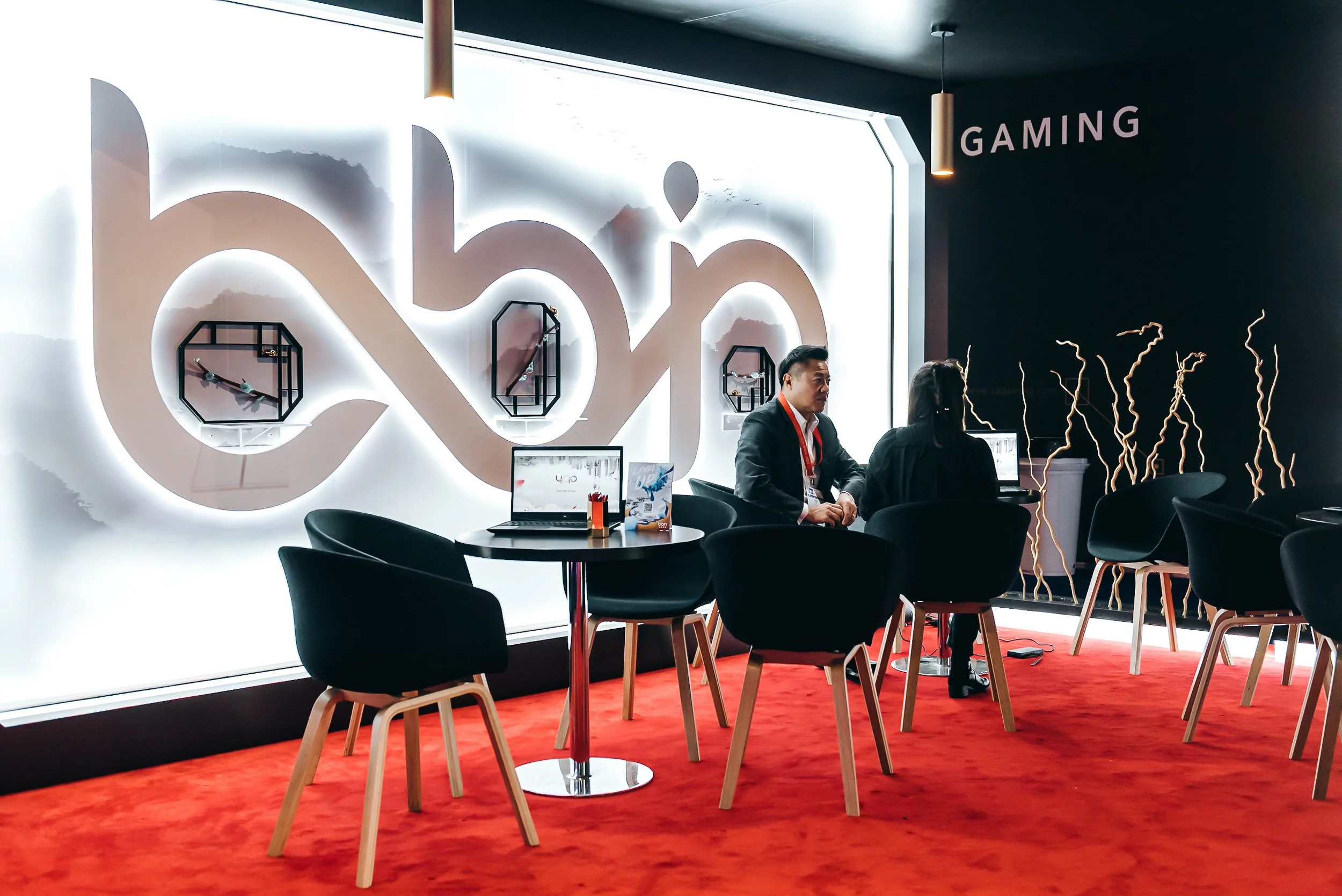 B2B clients conducting a private commercial consultation inside the custom-built BBIN exhibition meeting space at ICE London, ExCeL London. Premium corporate trade show and hospitality suite photography by Will Bailey.