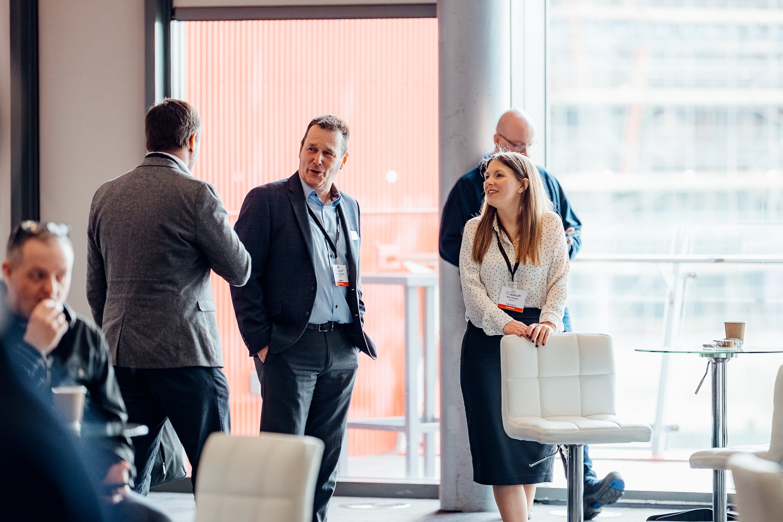 Corporate professionals networking during a morning coffee break at the Midwich Tech Xpo North, hosted at Old Trafford, Manchester. Candid B2B event photography by Will Bailey.