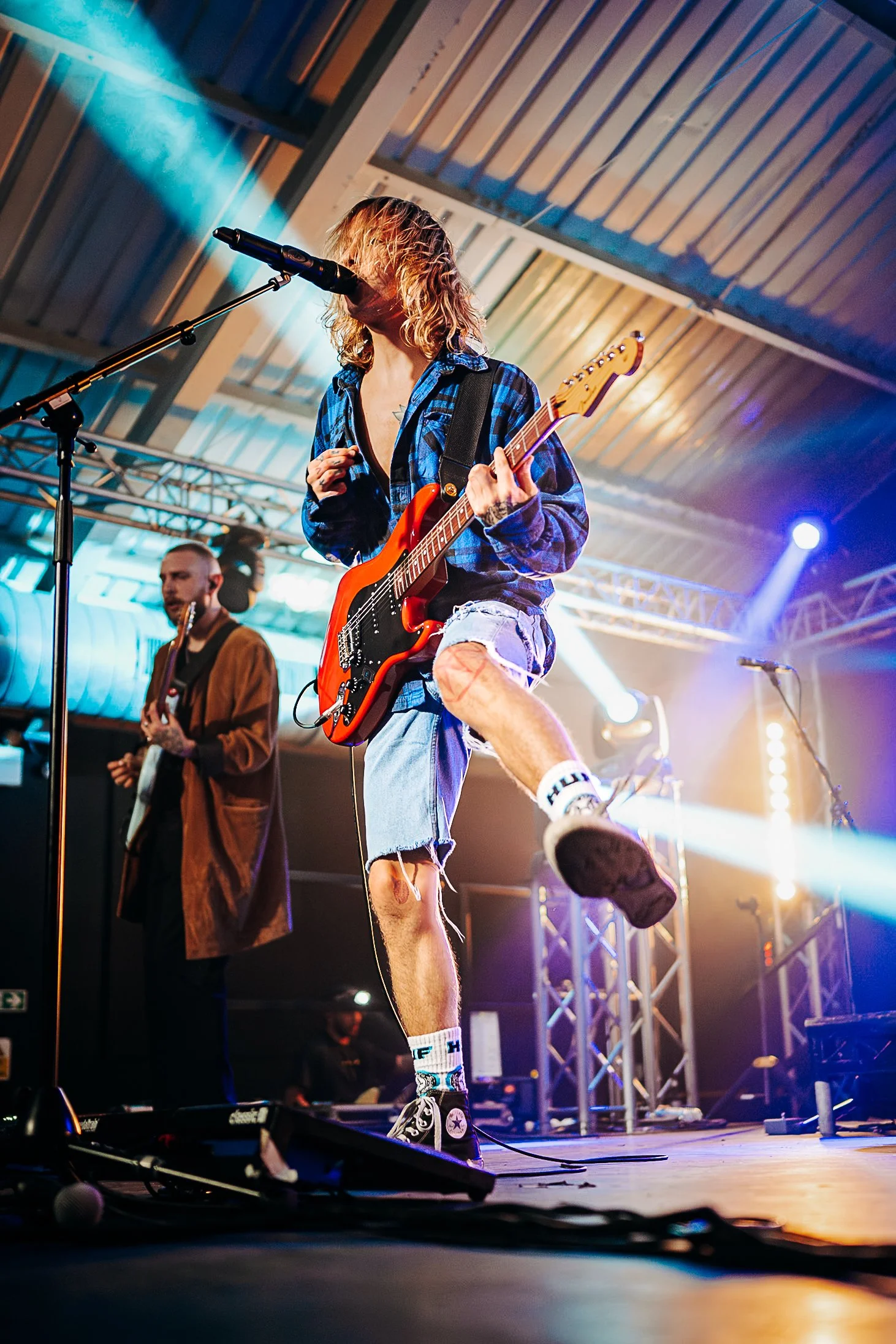 Low-angle dynamic stage photography of indie rock band The Hunna performing live at Engine Rooms, independent music venue in Southampton, captured under blue and teal stage spotlights by Will Bailey.