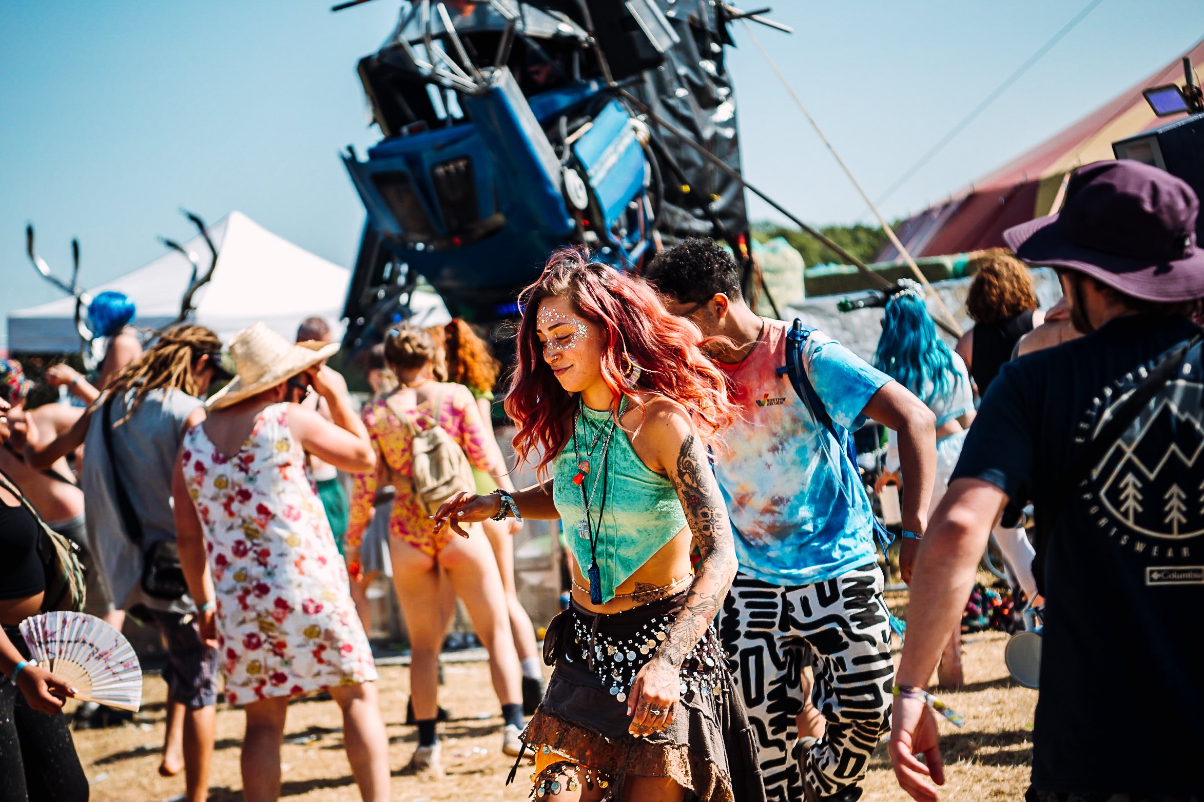 Candid festival lifestyle photography of a woman dancing freely in front of the giant blue Robot stage at Balter Festival, capturing summer event atmosphere by Will Bailey.