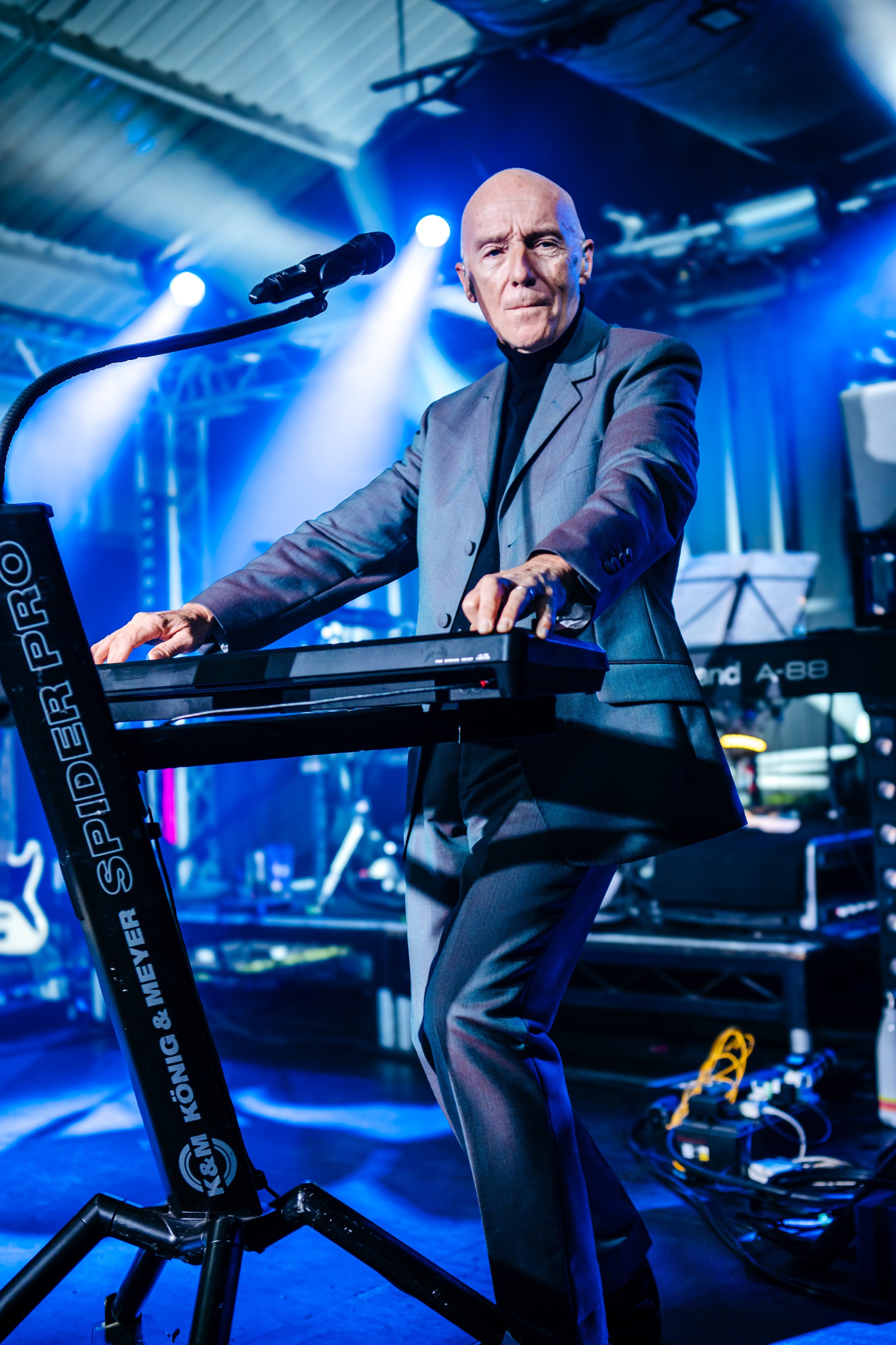 Electronic music pioneer Midge Ure performing on a professional synthesizer during an atmospheric live concert set at an independent music venue in Southampton, Hampshire. Synth-pop legend tour photography and creative stage lighting coverage by Will