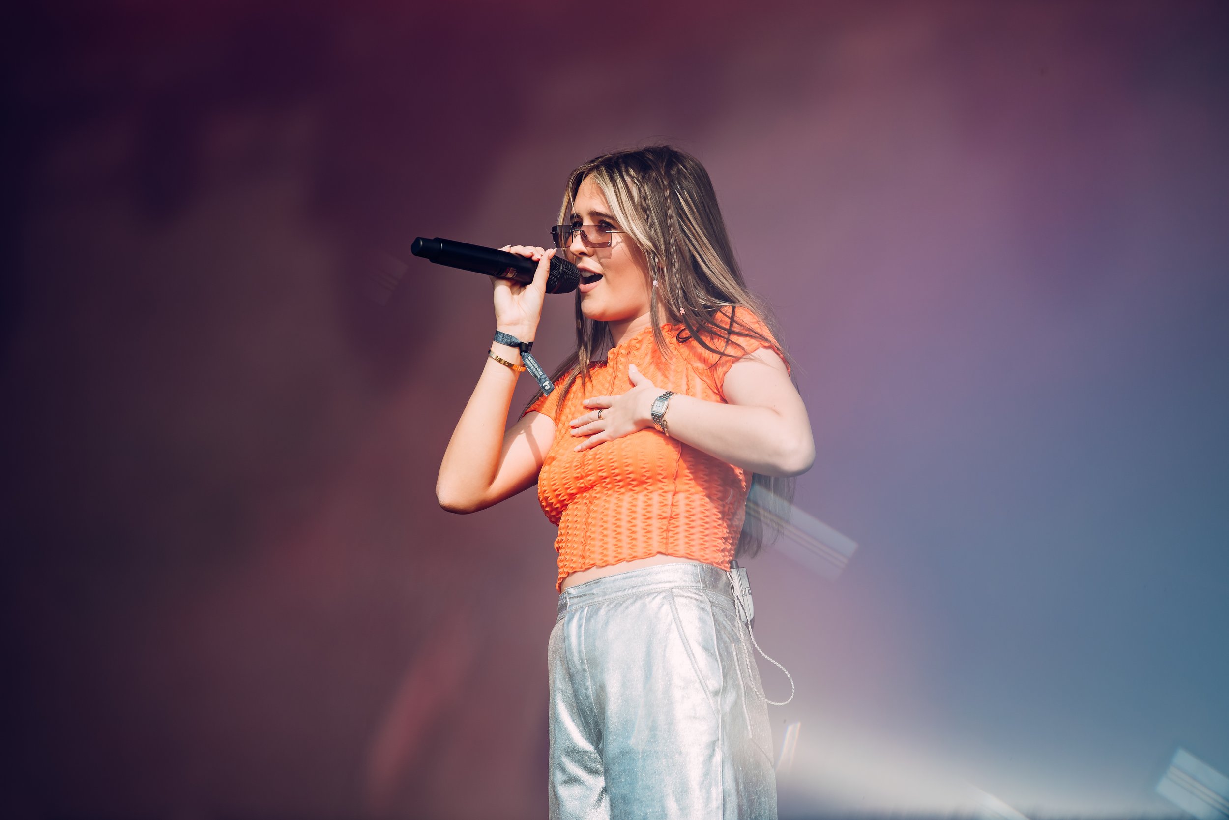 Pop singer Mimi Webb performing live on the main stage under a dramatic afternoon sky at Boardmasters Festival, Cornwall. Professional outdoor music festival and commercial pop concert photography by Will Bailey.