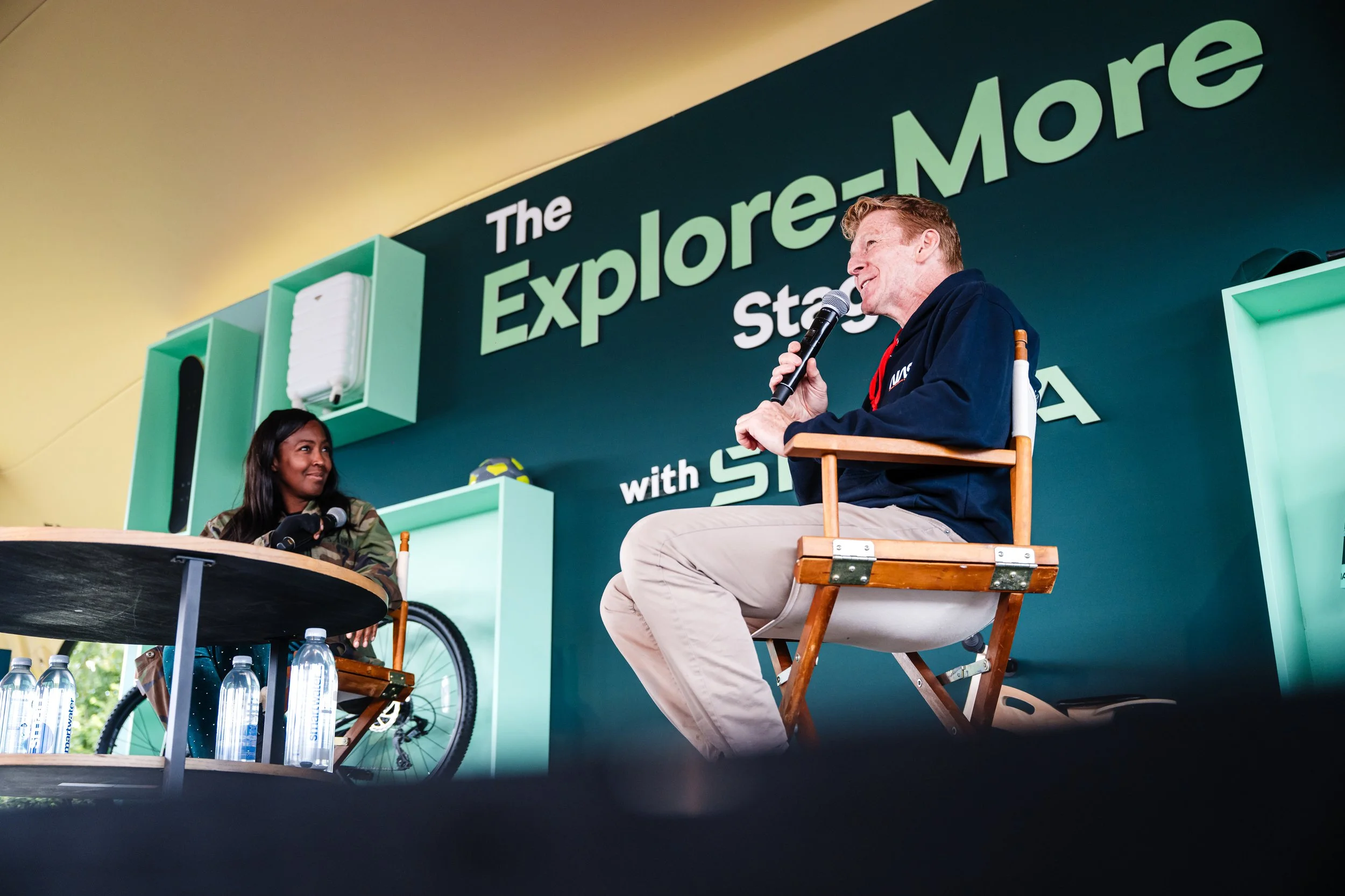 Astronaut Tim Peake speaking with broadcaster Angellica Bell live on the custom Explore More stage sponsored by Skoda at CarFest. Celebrity festival presentation and high-profile stage entertainment photography by Will Bailey.