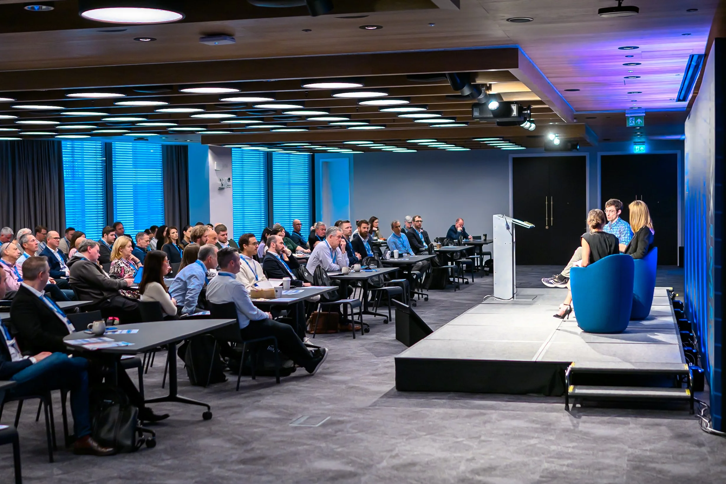 A live corporate panel discussion on stage during the NetDocuments Inspire conference at Convene 22 Bishopsgate, London. Professional B2B conference and summit photography by Will Bailey.