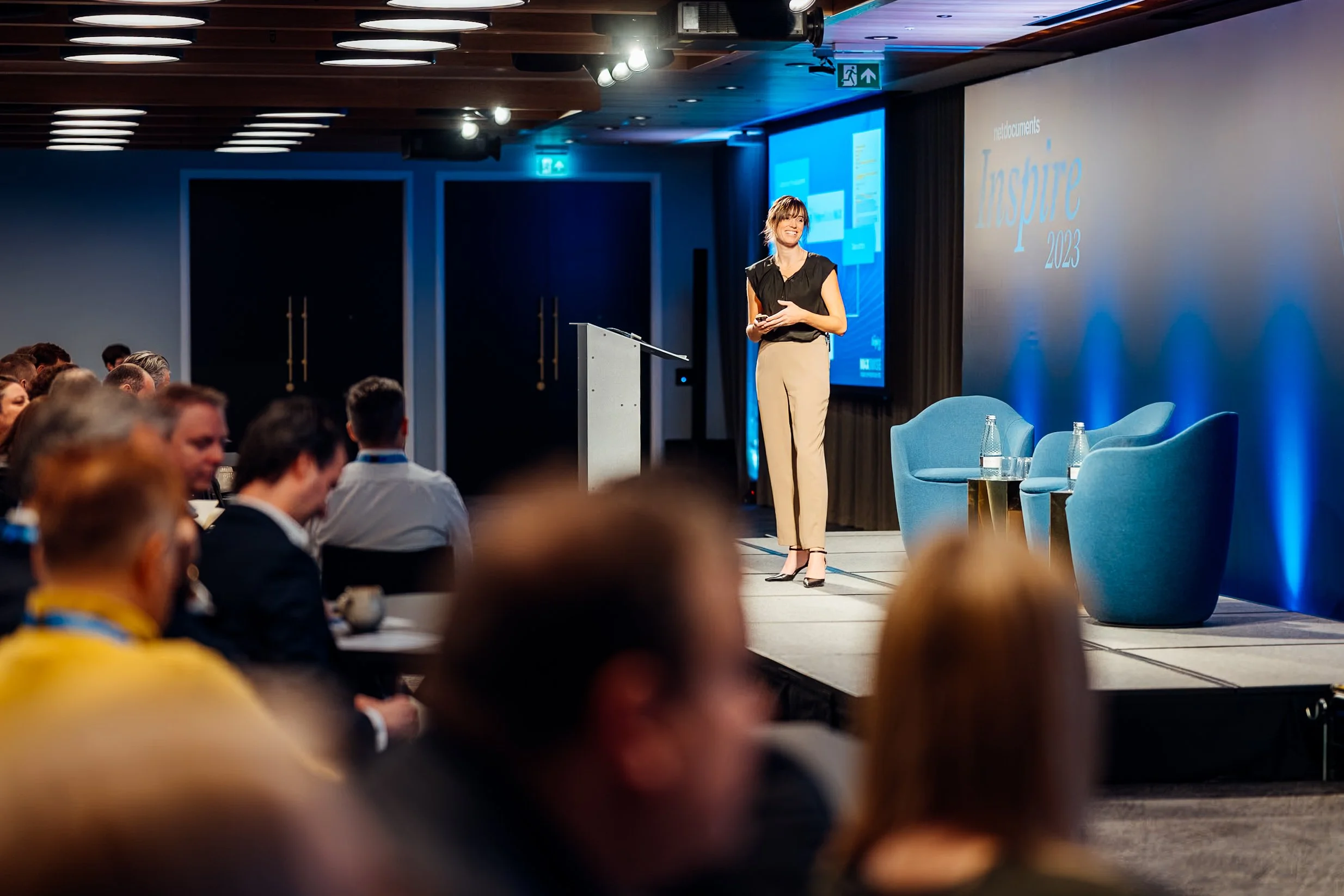 A keynote presenter on stage speaking to corporate delegates during the NetDocuments Inspire summit at Convene 22 Bishopsgate. Professional event presentation and seminar photography by Will Bailey.