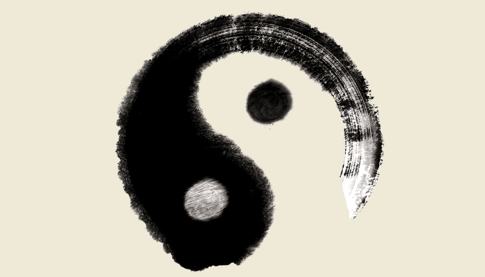 A painted Yin-Yang symbol with a black and white design on a light background.