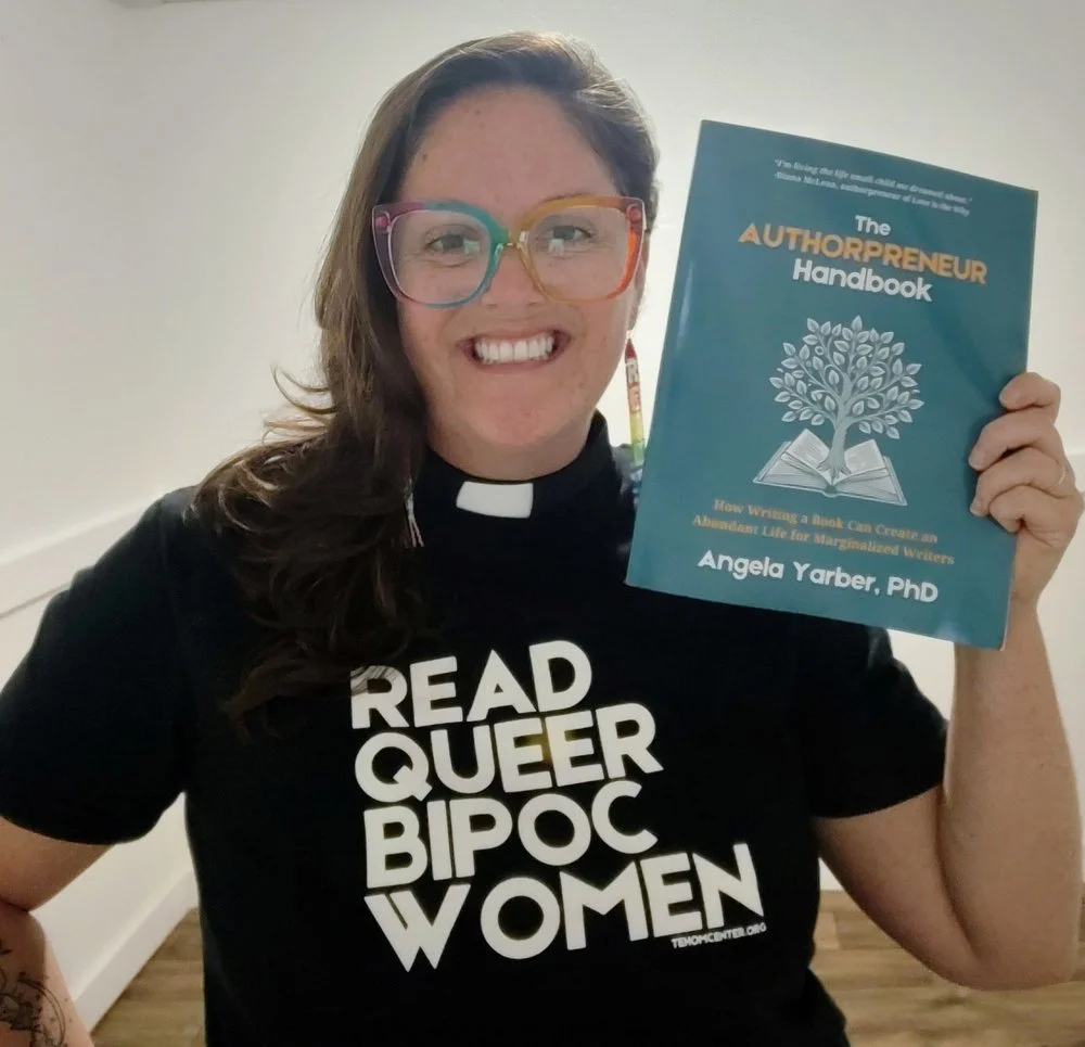 Rev. Dr. Angela Yarber holding the Authorpreneur Handbook published by Tehom Center Publishing