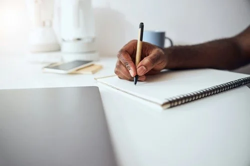 A hand writing, representing a Tehom Center Publishing team member