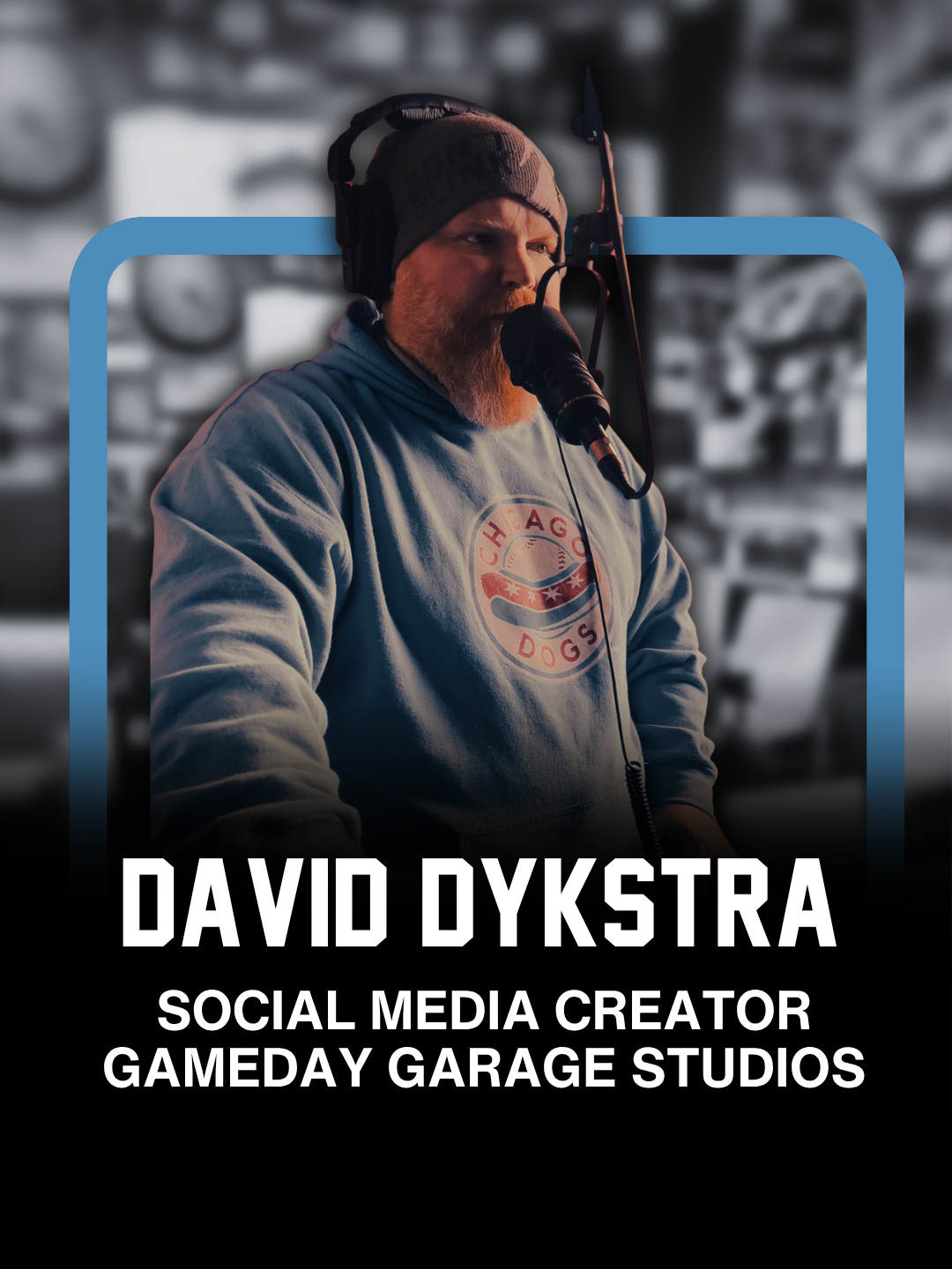 A man with a beard wearing a gray beanie, headphones, and a Jayhawks hoodie, speaking into a microphone in a recording studio with blurred background.