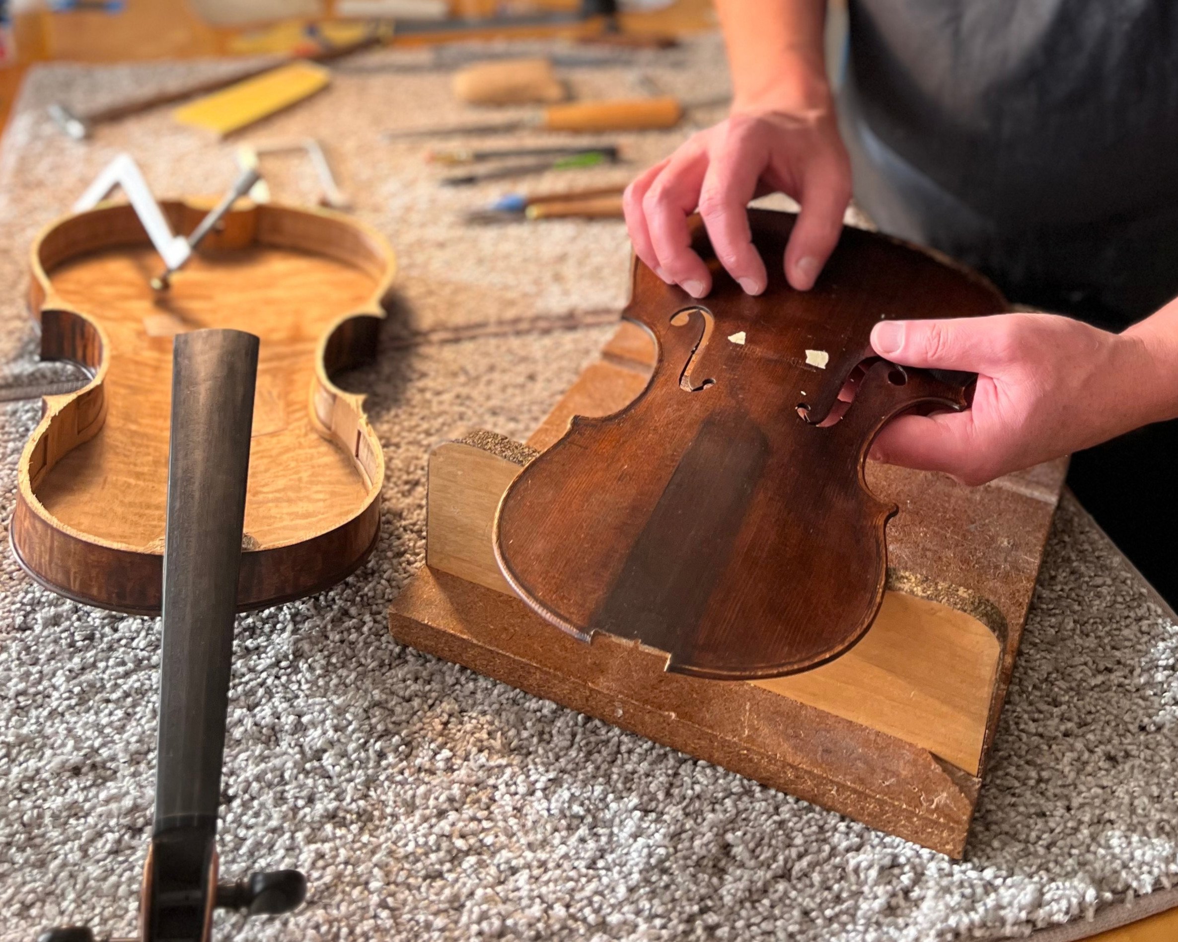 Peter Bingen repairs a violin in his workshop.