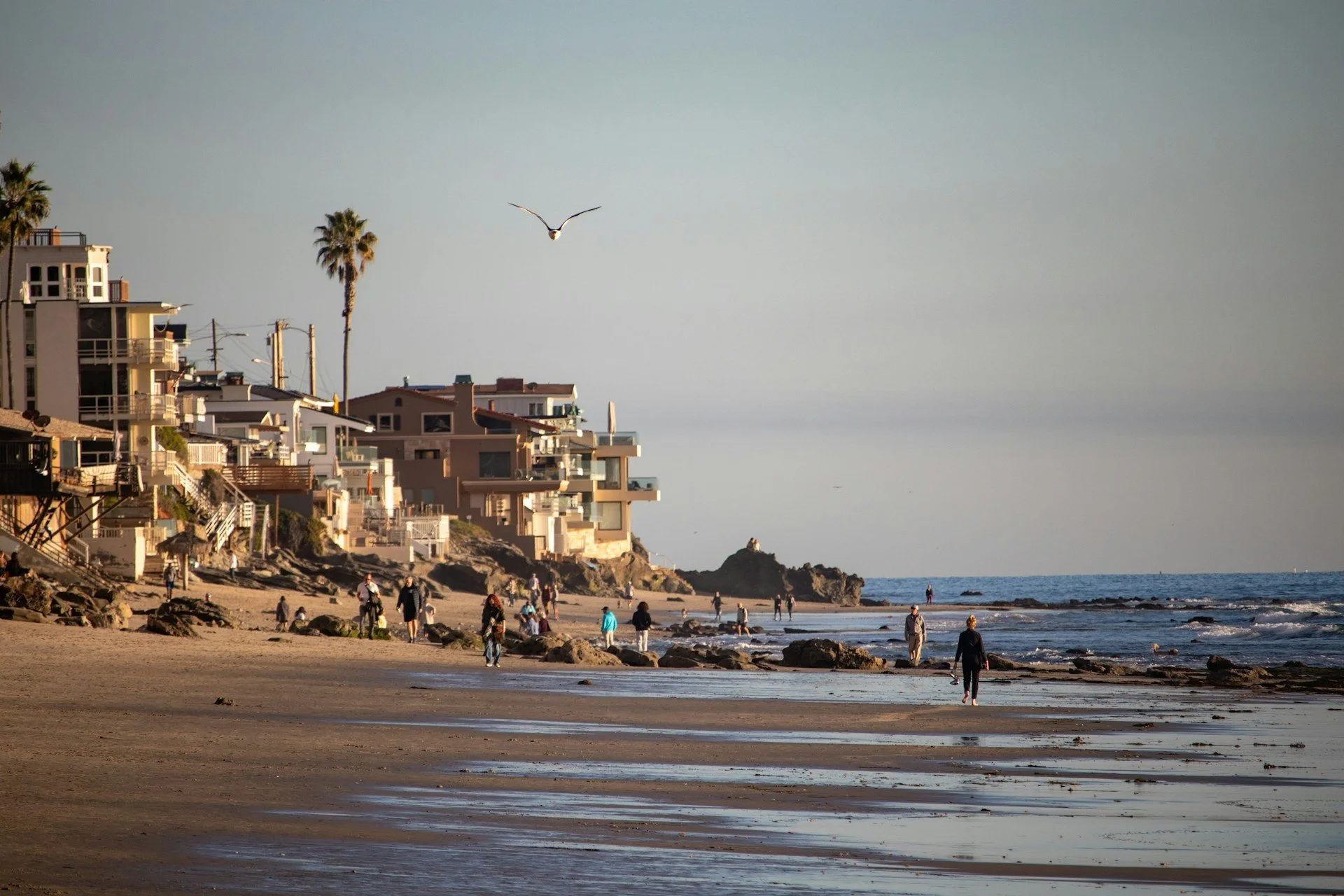 People walking on the beaches of Laguna Beach during sunset and lowtide