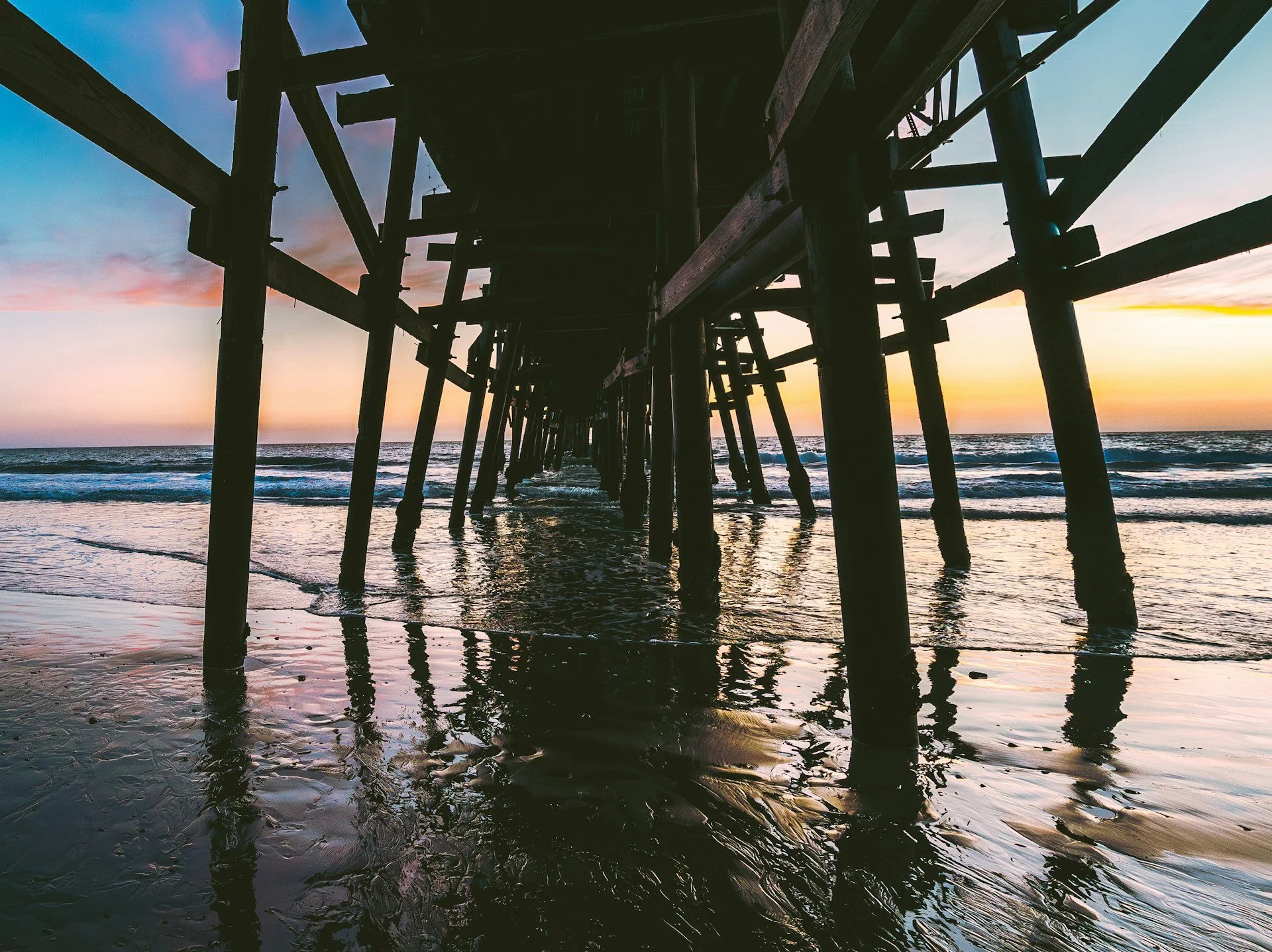 image of the San Clemente pier from underneath with the sunset in the background