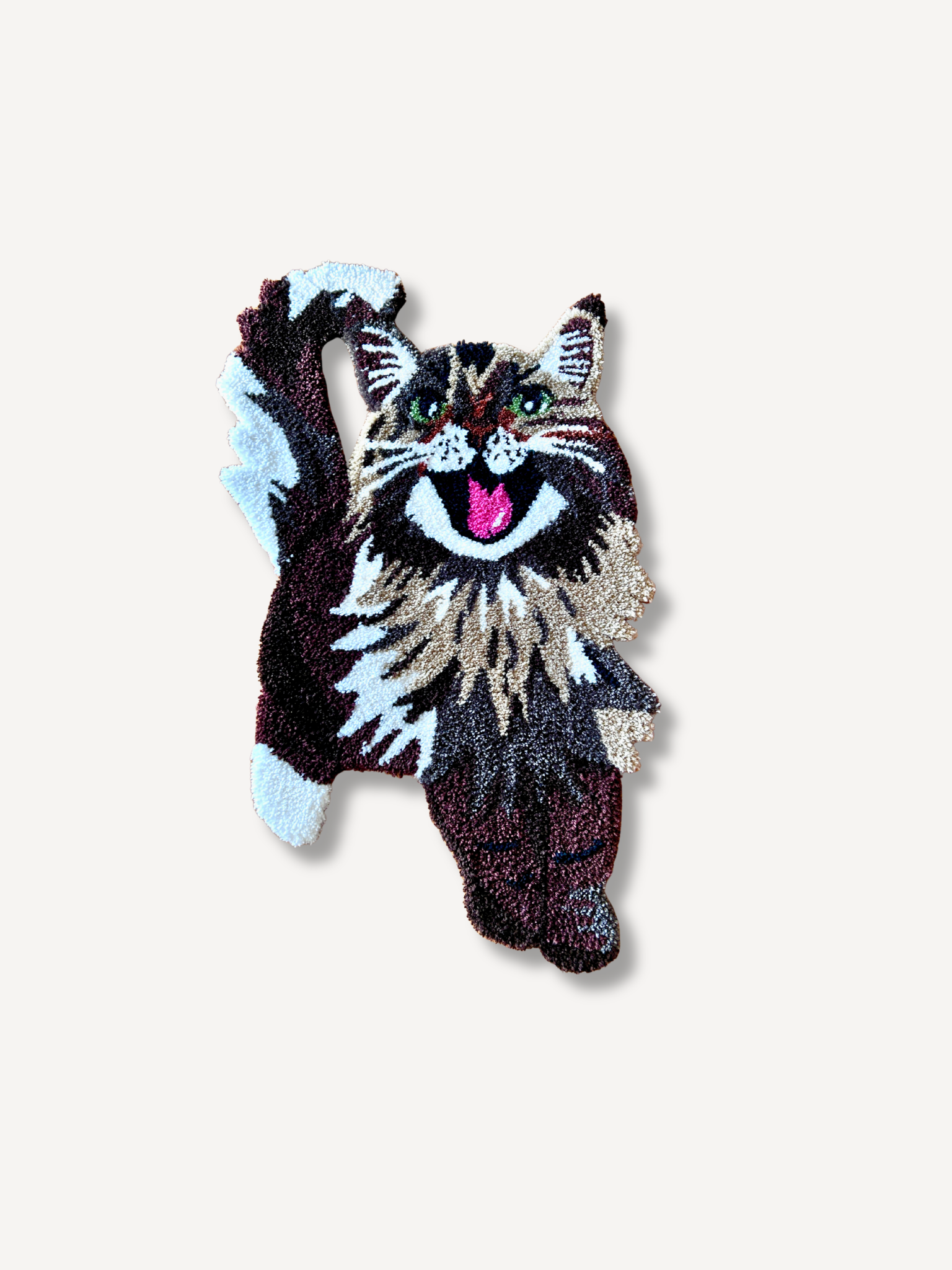 A tapestry in the shape of a dog, featuring a detailed depiction of a dog with its tongue out and fur in shades of black, white, brown, and pink, against a plain light background.