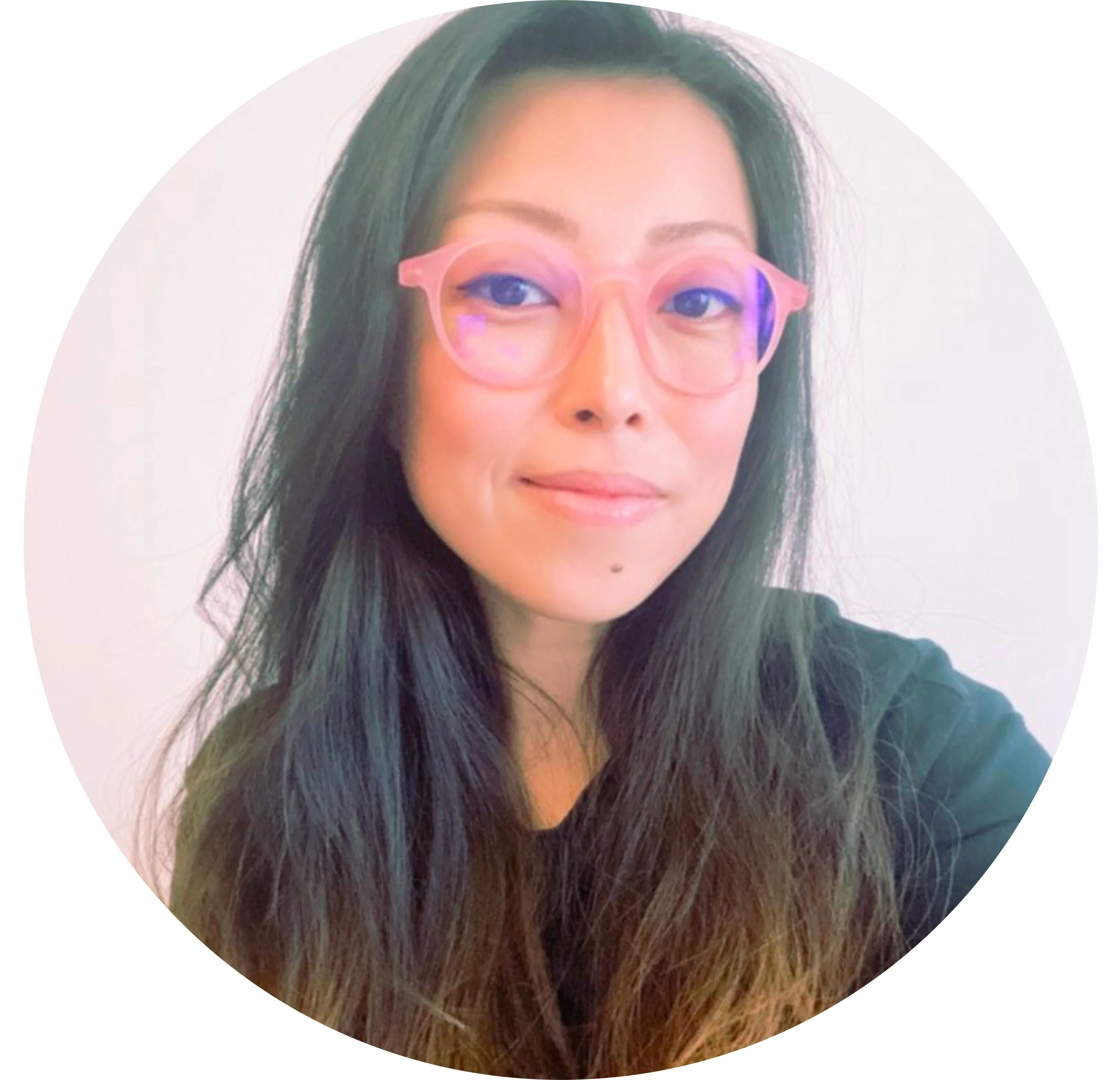 A woman with long dark hair wearing pink glasses with purple accents.