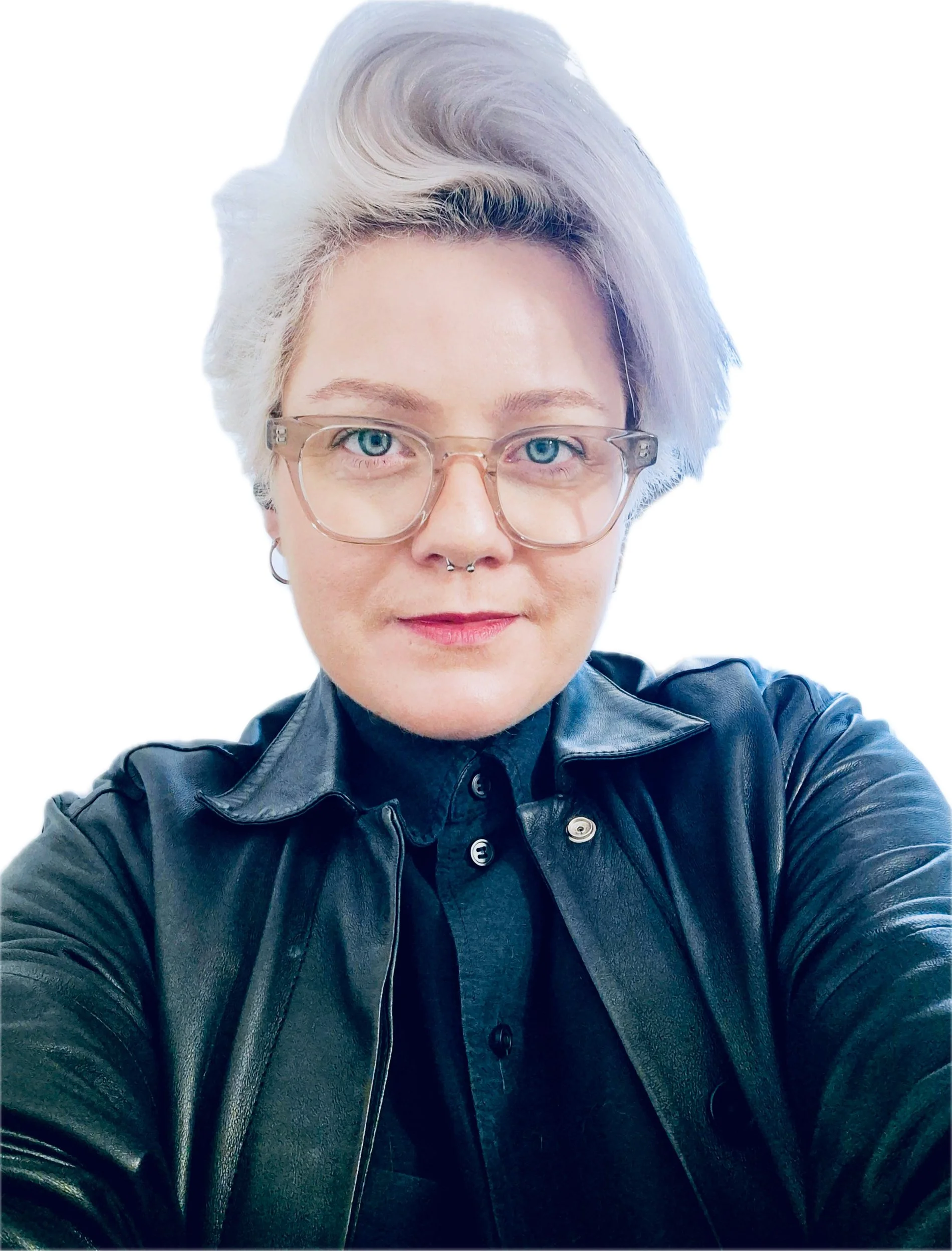 A person with short, styled gray hair, wearing clear glasses, a black leather jacket, and a black shirt, taking a selfie against a white background.