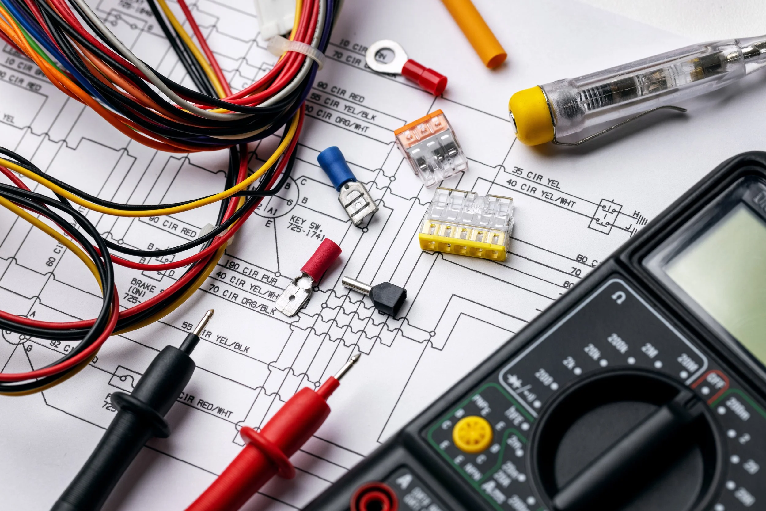 Electronic testing equipment, wires, and electrical components placed on a technical circuit diagram