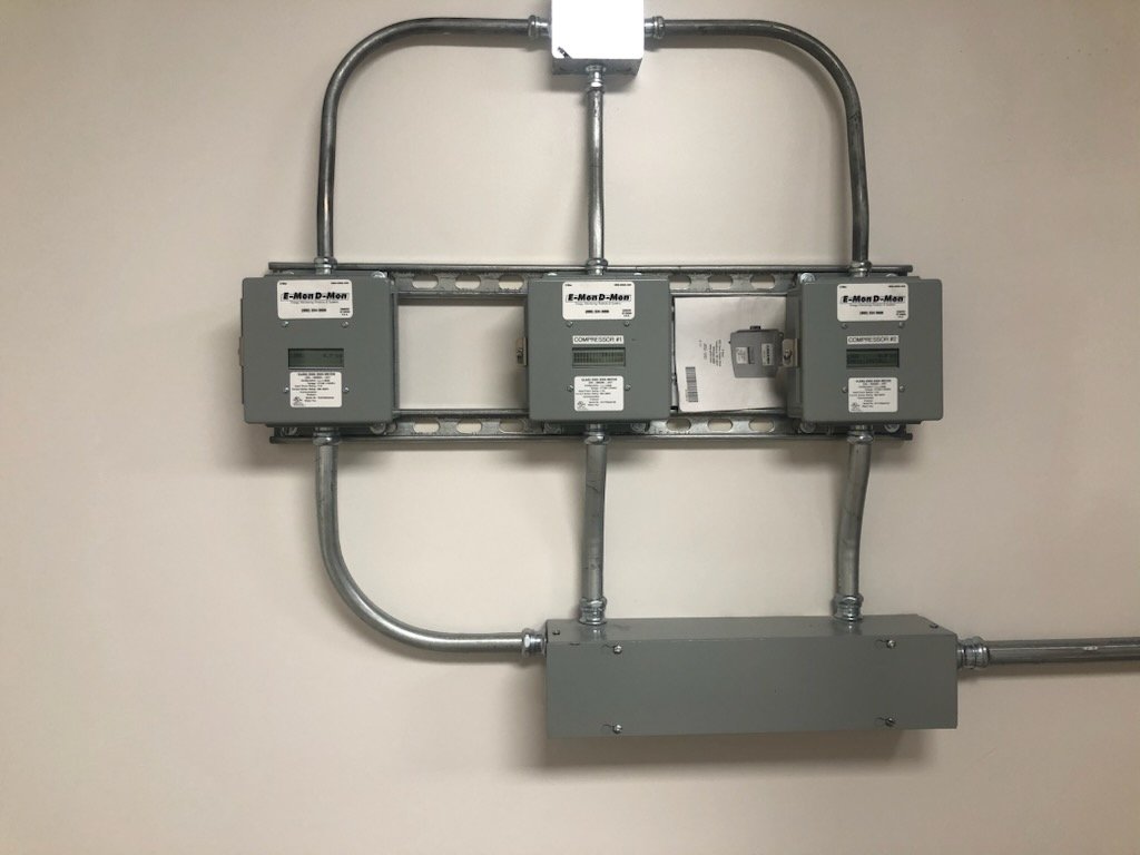Professional installation of E-Mon D-Mon electrical monitoring meters with clean conduit routing and organized commercial power distribution setup.