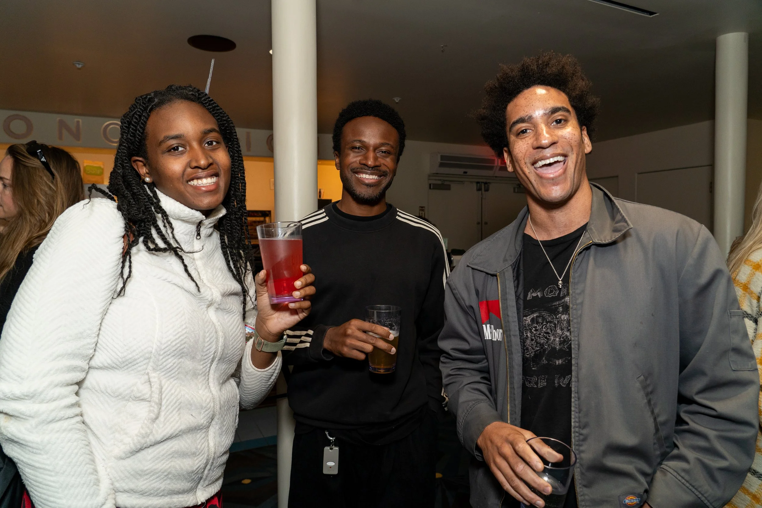  Three guests smiling and holding drinks at the Familiar Touch special preview screening in Los Angeles. 