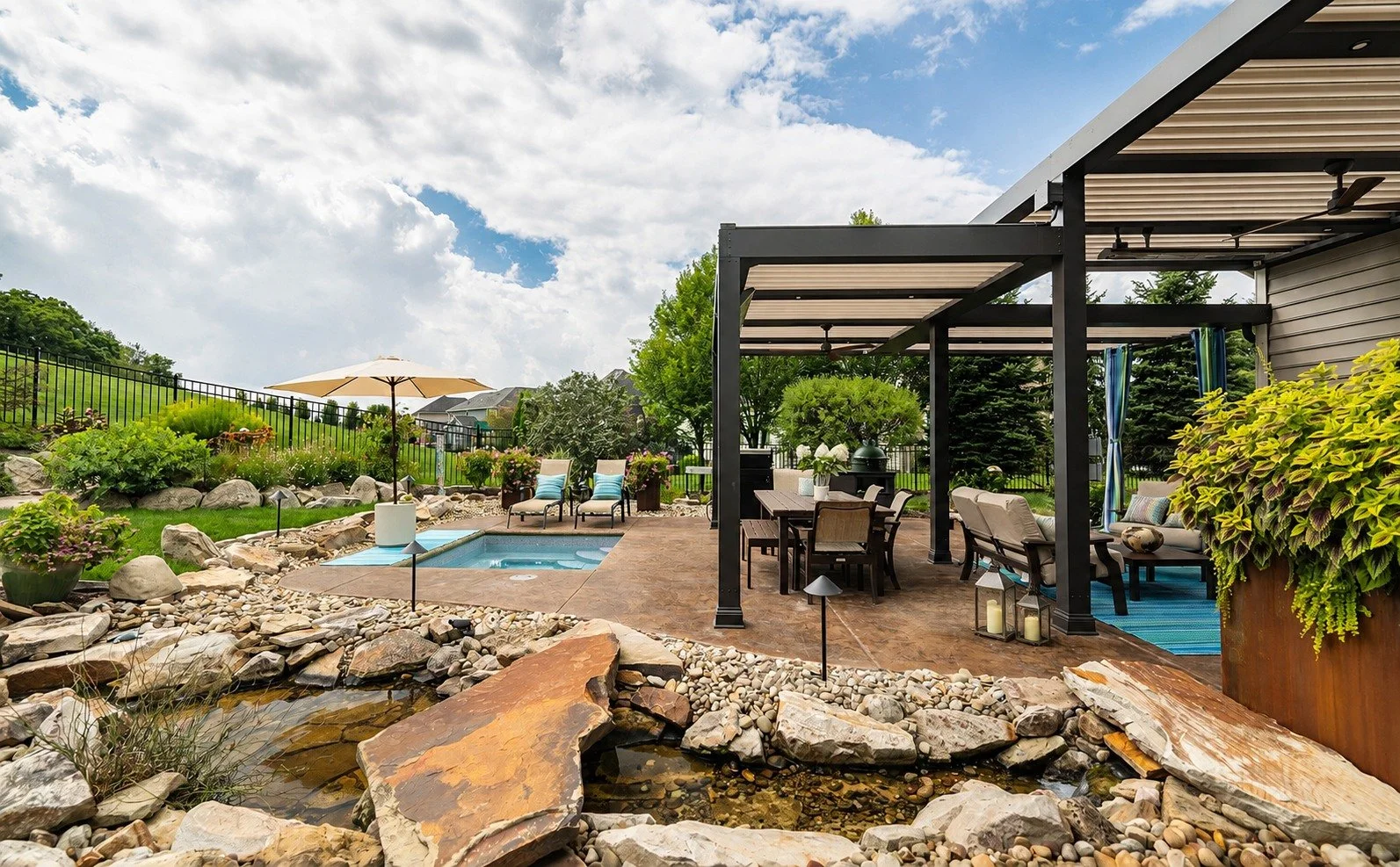 The centerpiece of this outdoor living project is a custom, two-tier StruXure pergola designed to make the space comfortable and usable through just about every season.

Three motorized louvered roof sections can open up to the sun or close for cover