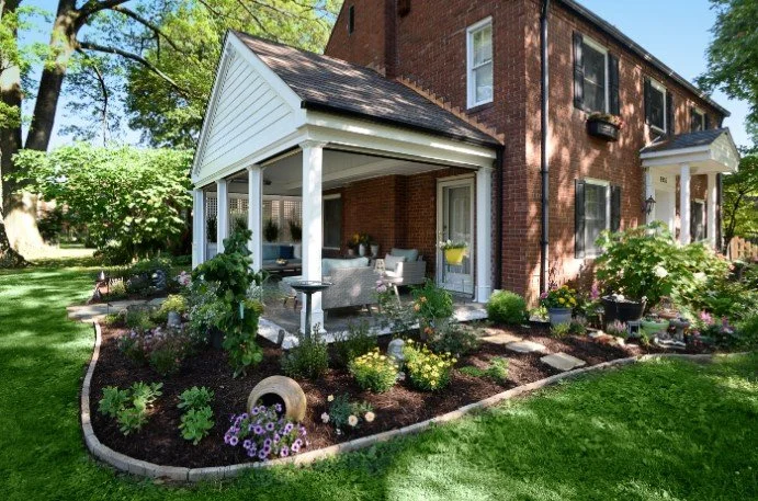 brick home with a side porch and a well-maintained yard