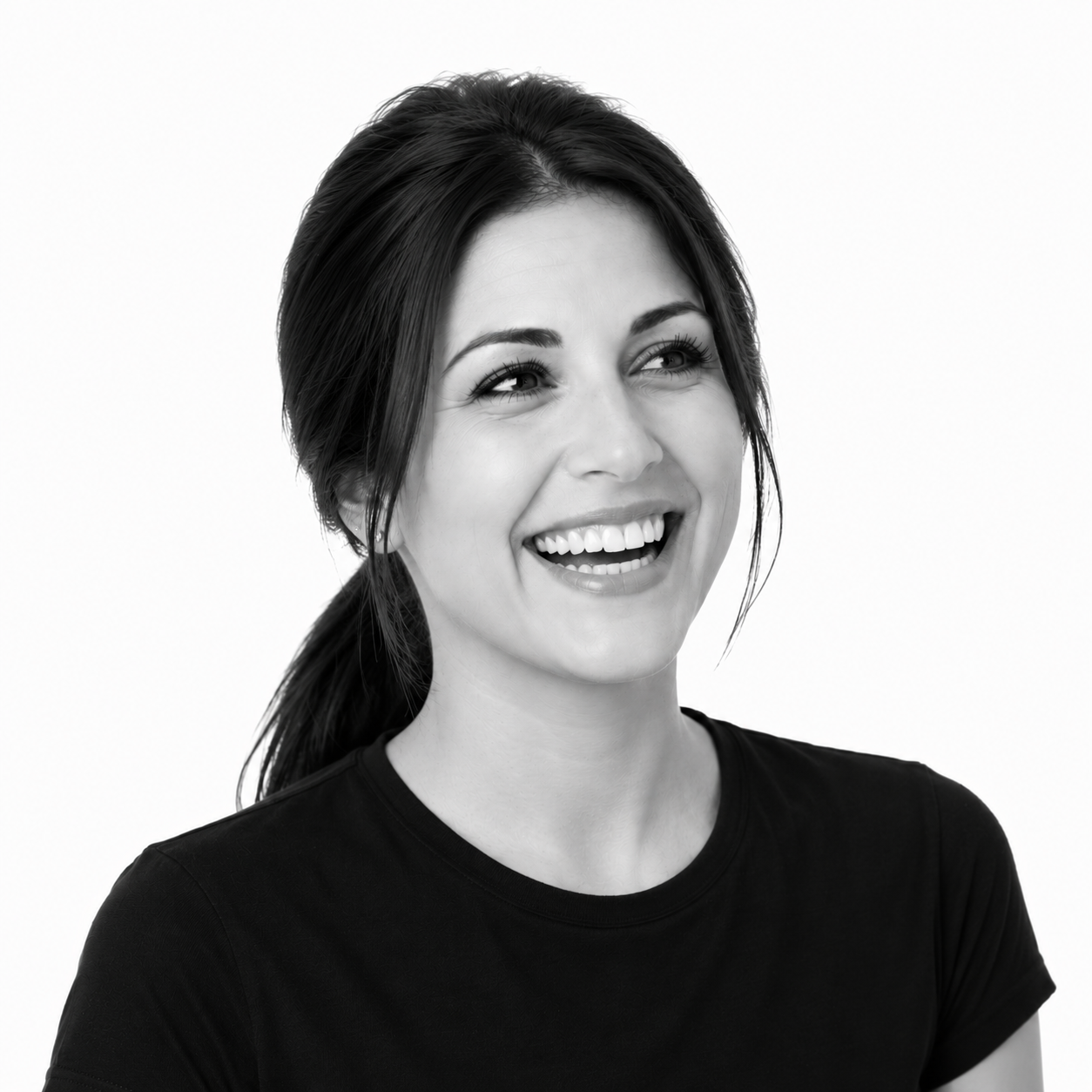Black and white portrait of a young woman smiling and looking to her left, wearing a black t-shirt with her dark hair tied back.