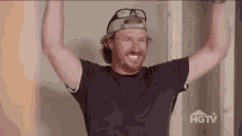 Animated GIF of Chip Gaines raising his arms in celebration.