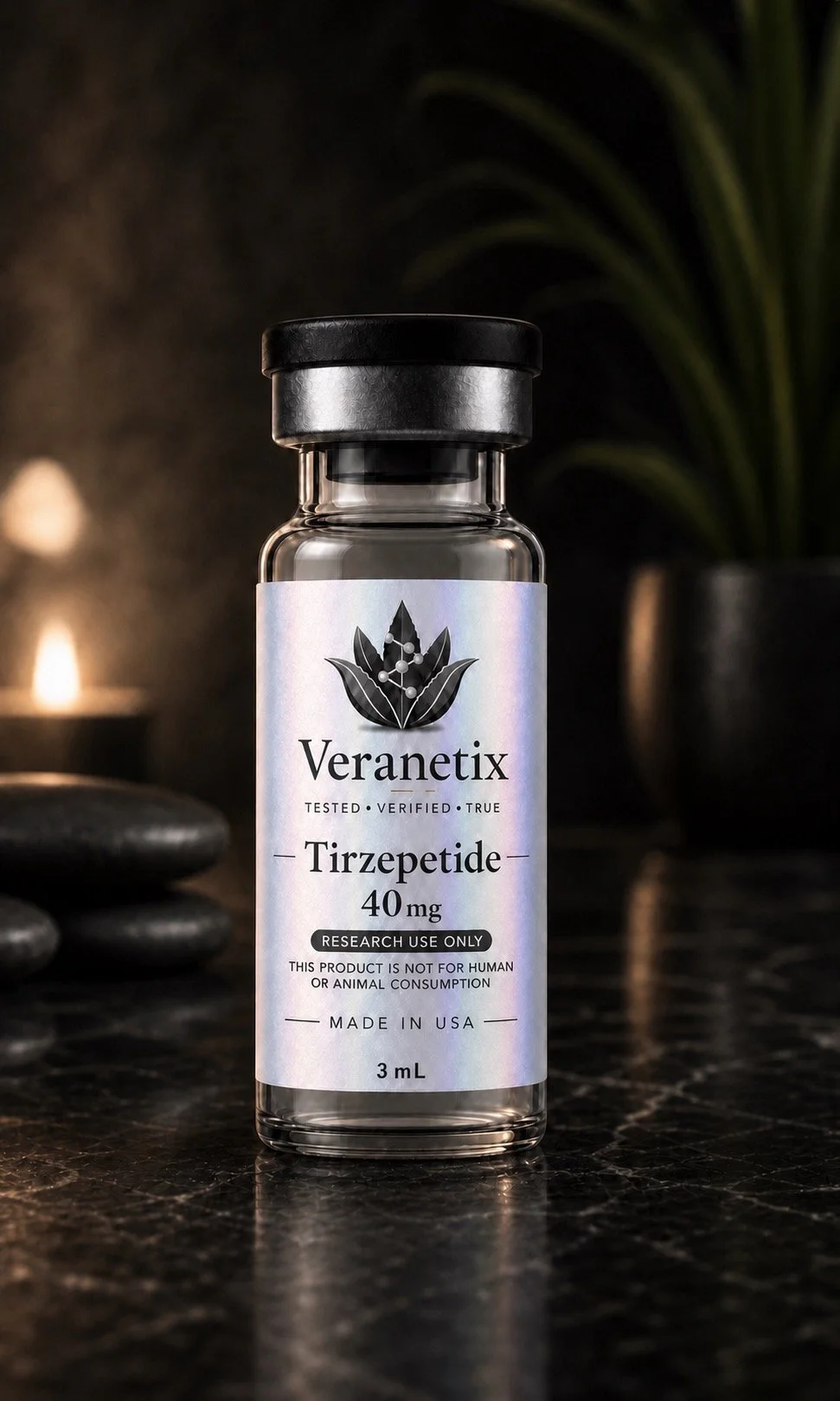 A small glass vial labeled 'VeranTix Tirzepatide 40 mg' with a black cap, placed on a dark surface with rocks and a blurred background including a plant.