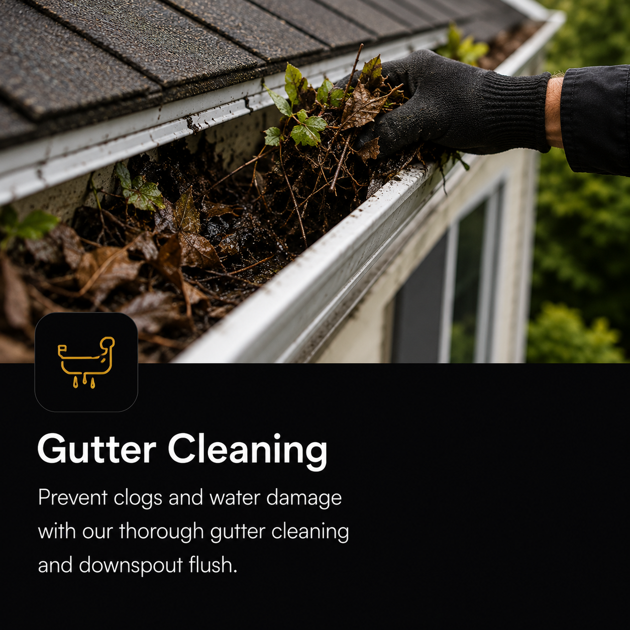 A person wearing a black glove cleaning leaves and debris from a house gutter.