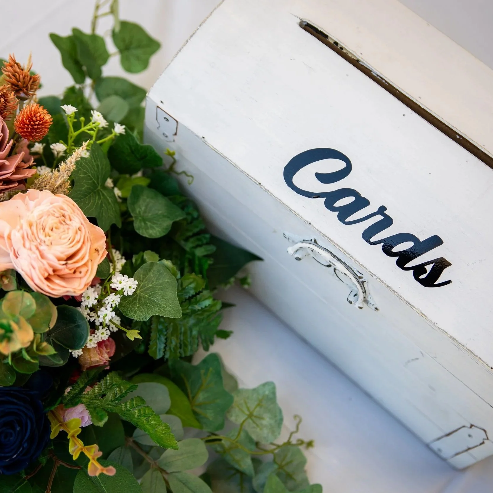 A white box with the word 'Eardash' written on it in blue letters, surrounded by various flowers and green leaves.