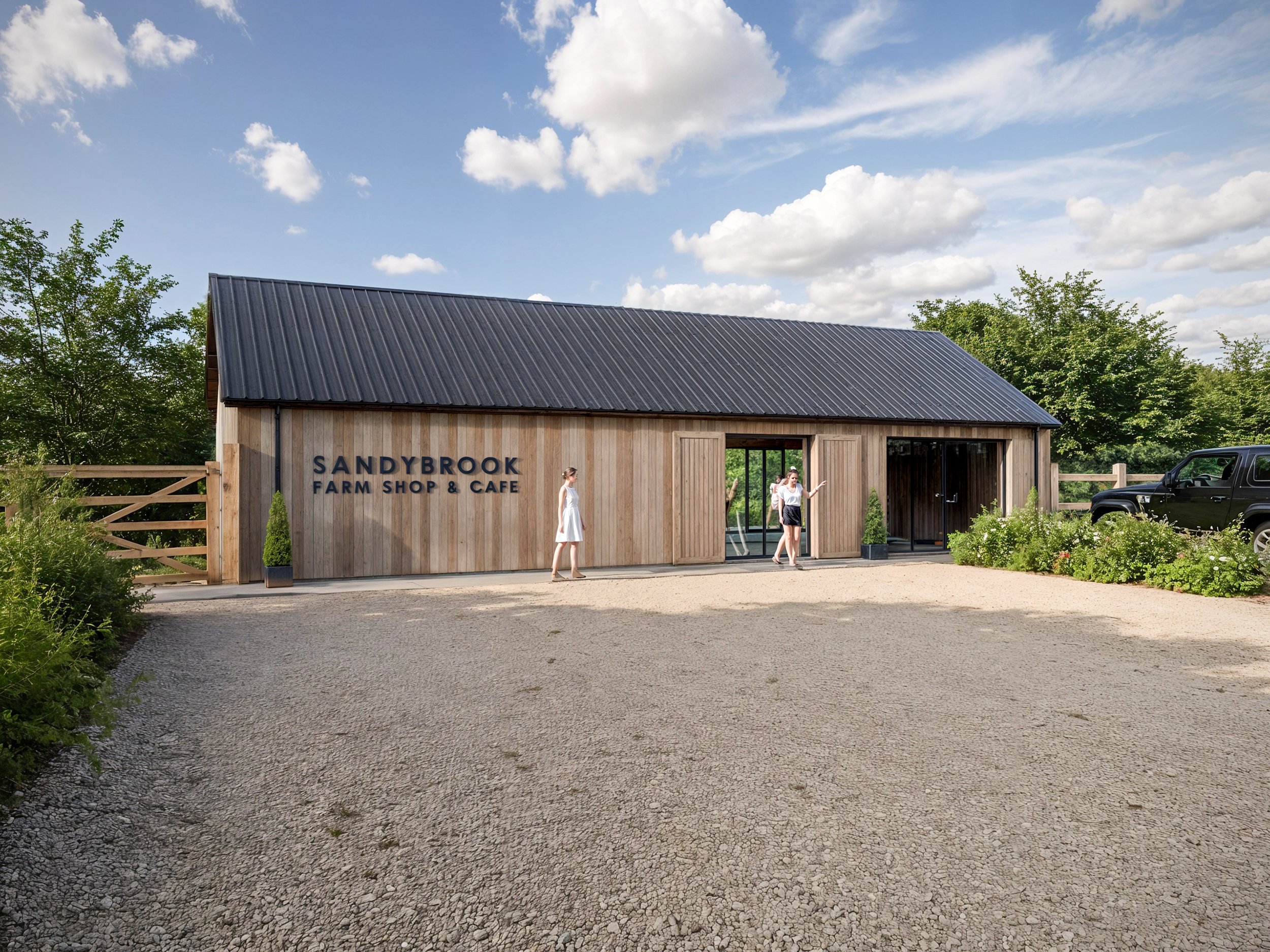 Building with a sign that reads 'SANDYBROOK FARM SHOP & CAFE' under a partly cloudy sky, with trees and parked vehicles nearby.