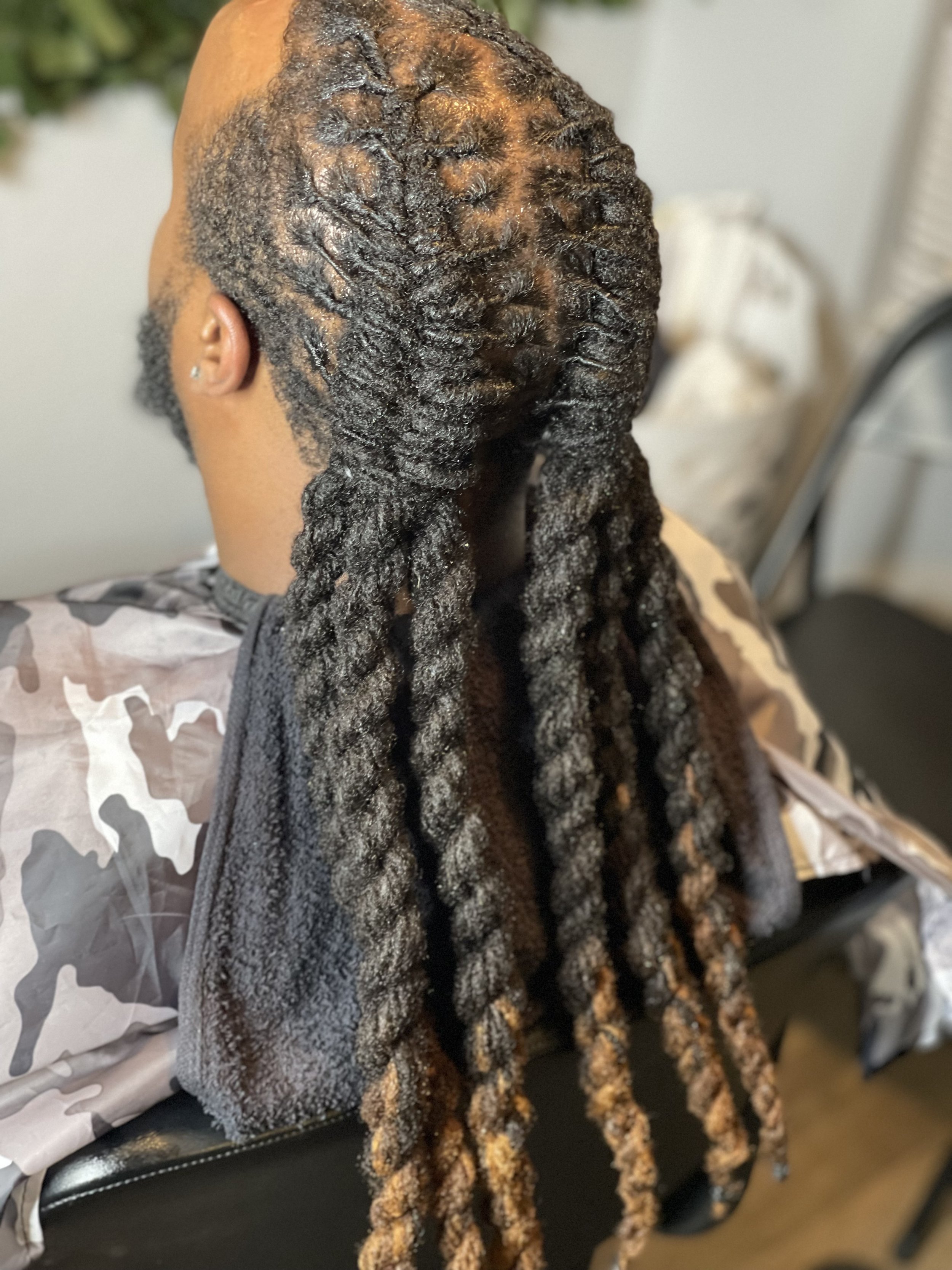 Fresh retwist on long locs. Styled with two fishtail loc braids and two strand twists.