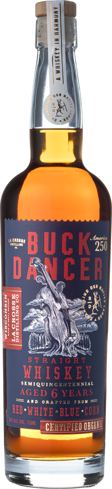 A bottle of Buck Dancer straight whiskey with a blue and red label, featuring a tree with a violin in its branches and text indicating it is aged 6 years, organic, and crafted from corn, white, red, and blue colors, 750ml size.