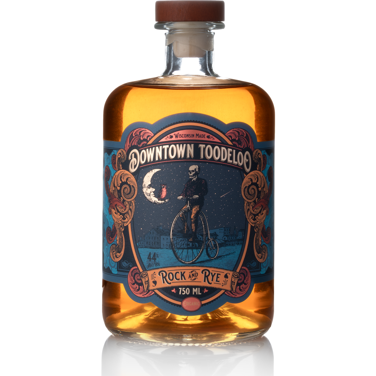 Bottle of Downtown Toodeloo Rock and Rye with an illustrated label featuring a skeleton riding a penny-farthing bicycle under a night sky with a crescent moon, stars, and a moonlit landscape.